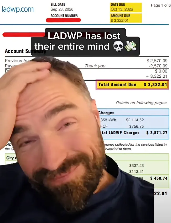 A man holding his head in disbelief in front of a high utility bill.