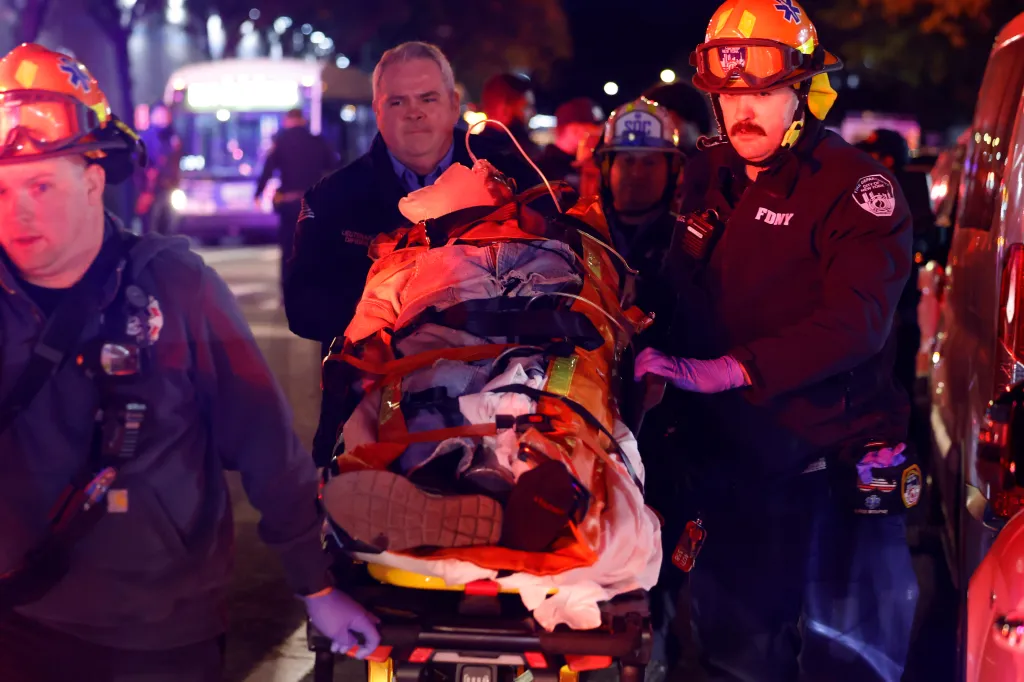First responders wheel a victim on a stretcher to an ambulance at the scene of a shooting.