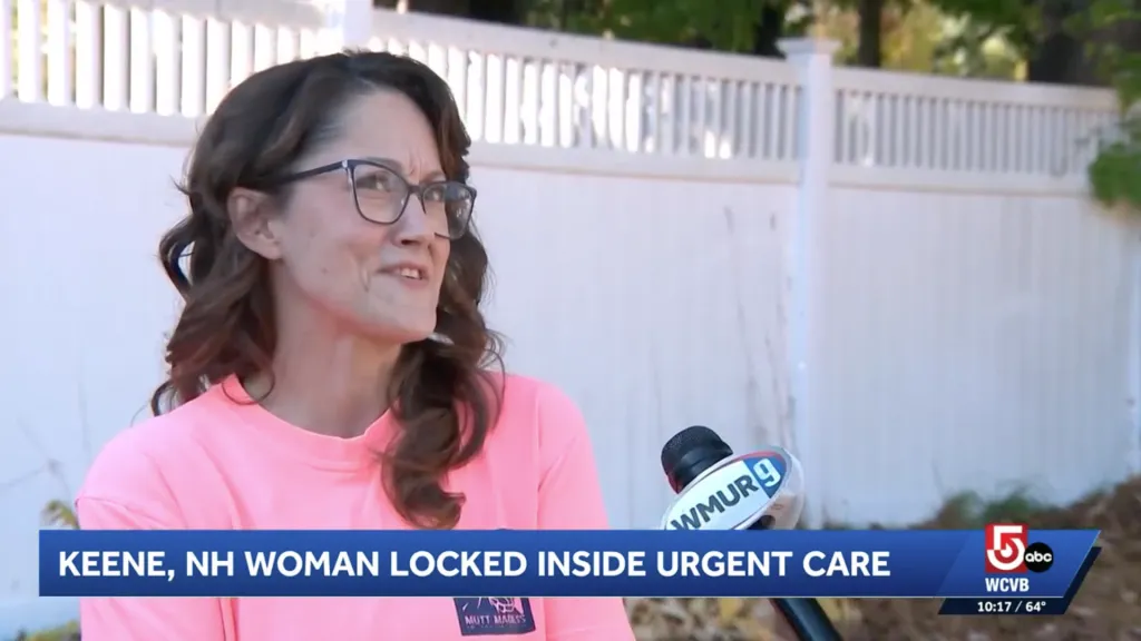 Tia Chandler speaks into a news microphone in front of a white fence.