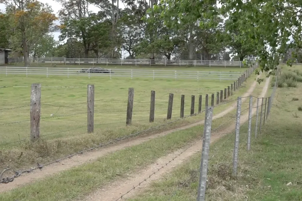 A dirt track runs alongside a barbed wire fence in Grafton, Australia, where a 5-year-old boy was found dead in a home.