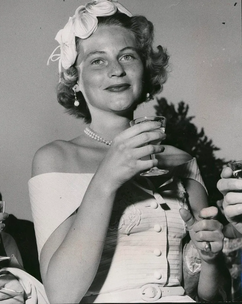 Gunilla von Post holds a glass of champagne at a pool party.