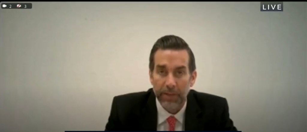 Jason Galanis testifying from prison in a live broadcast.