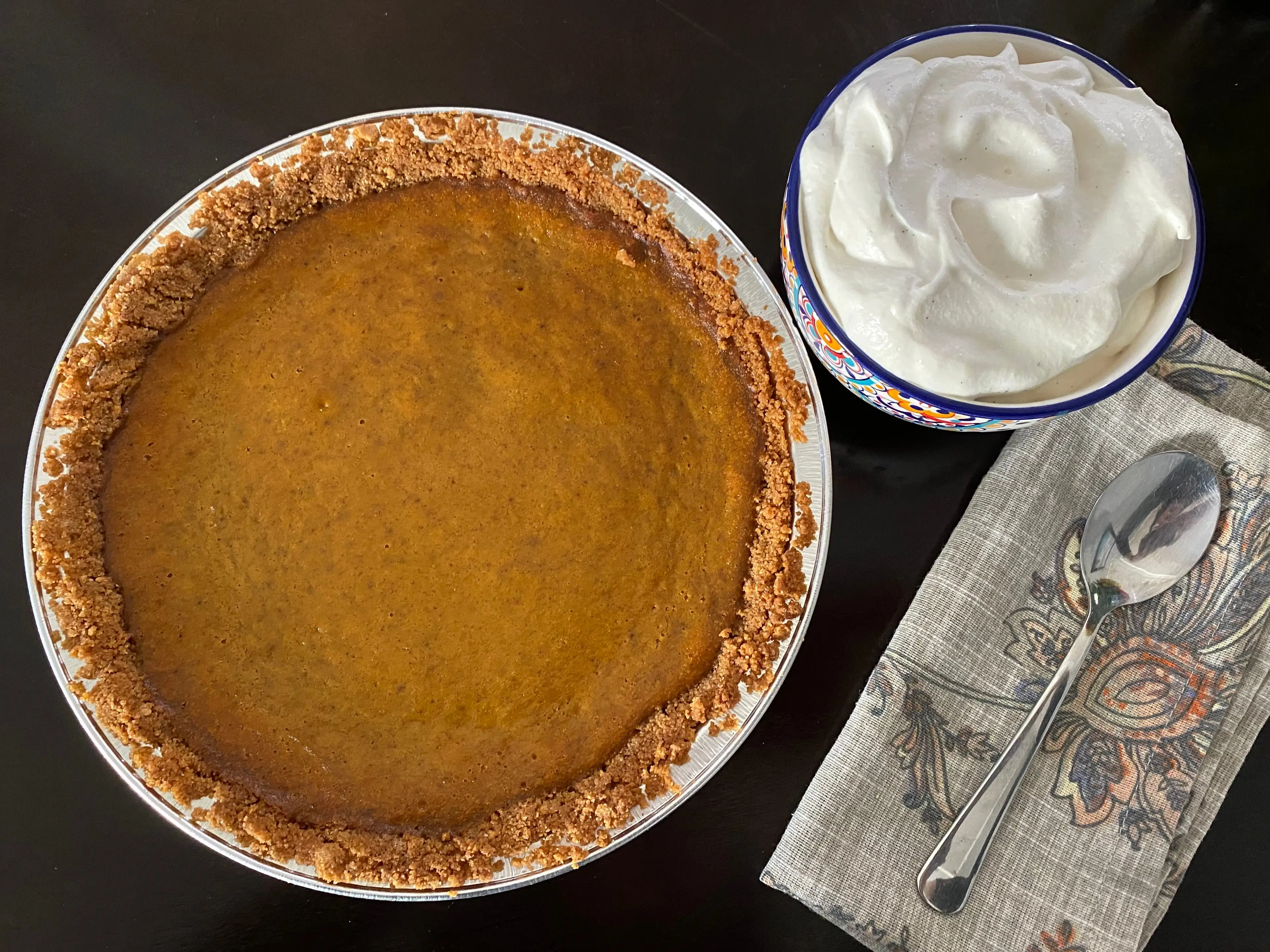 Bobby Flay final whole pumpkin pie with whipped cream next to it