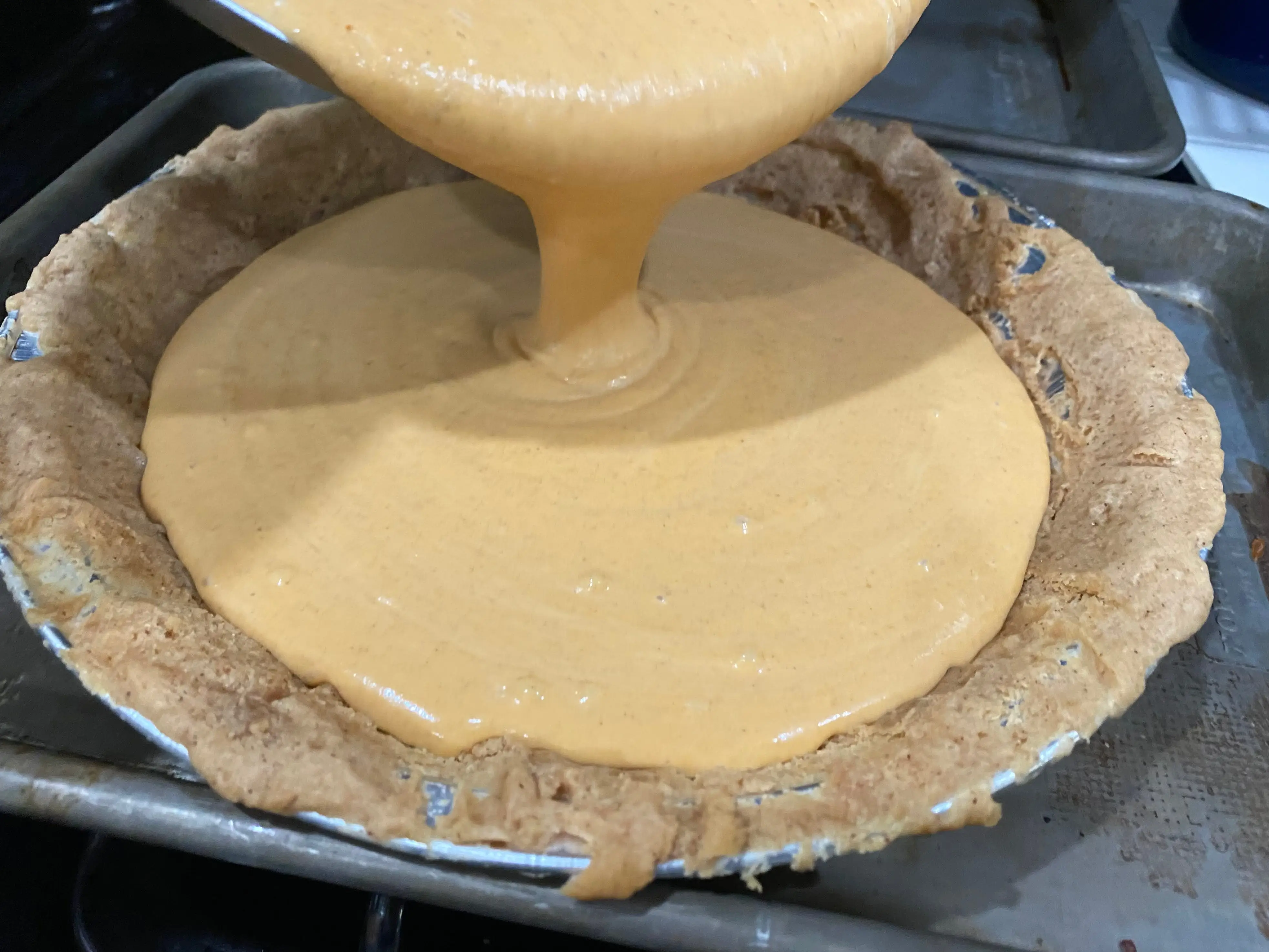 Dominique Ansel pumpkin pie filling  being poured into crust
