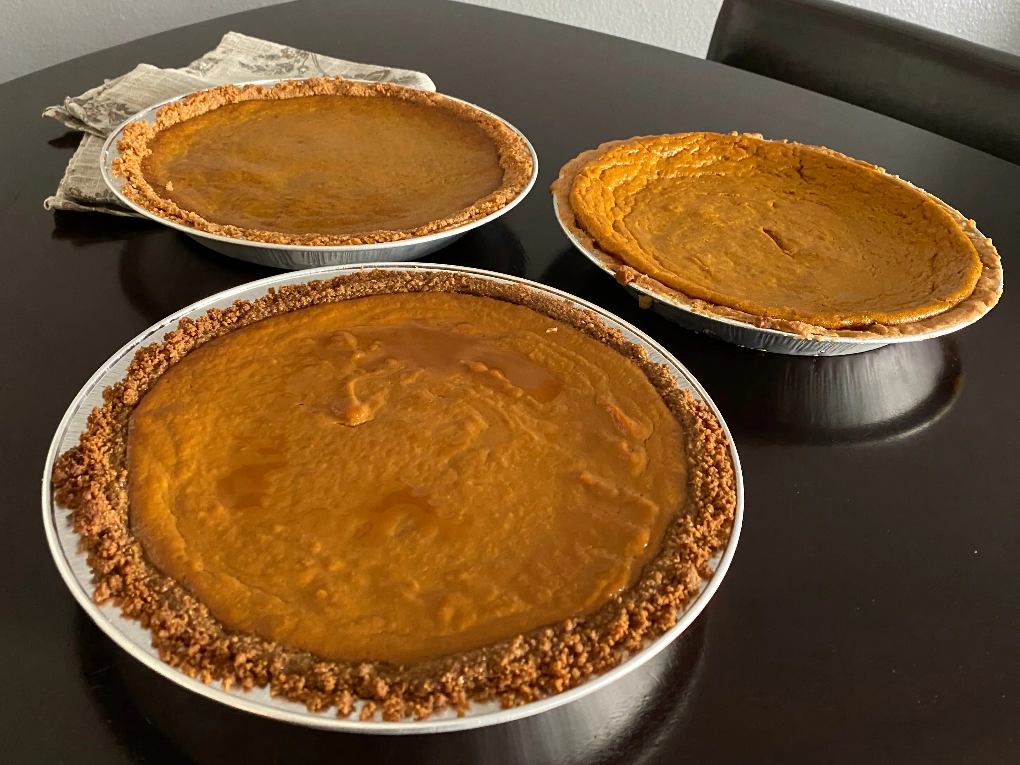 Three pumpkin pies on table