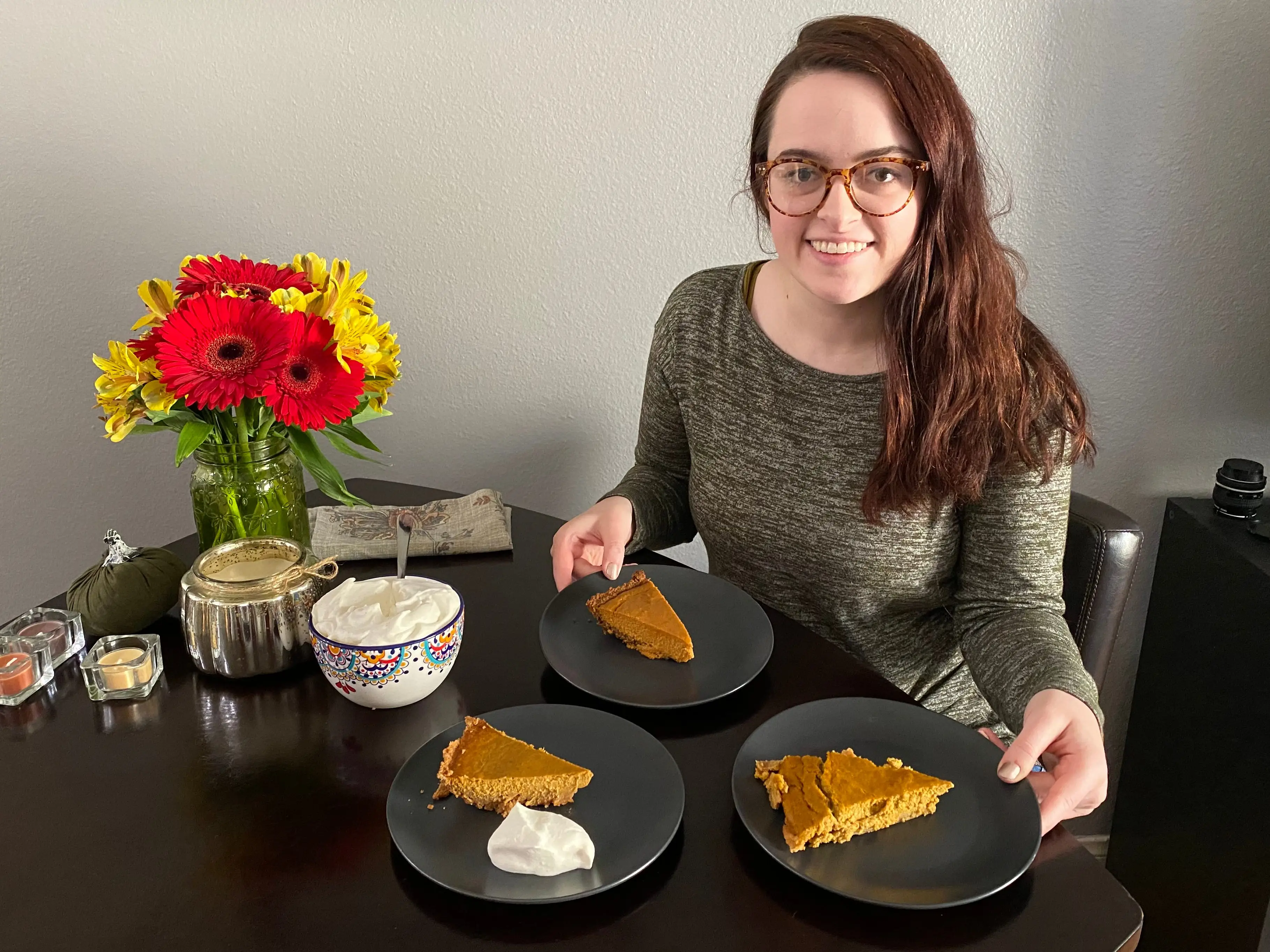 Woman posing with three slices of pumpkin pie on plates
