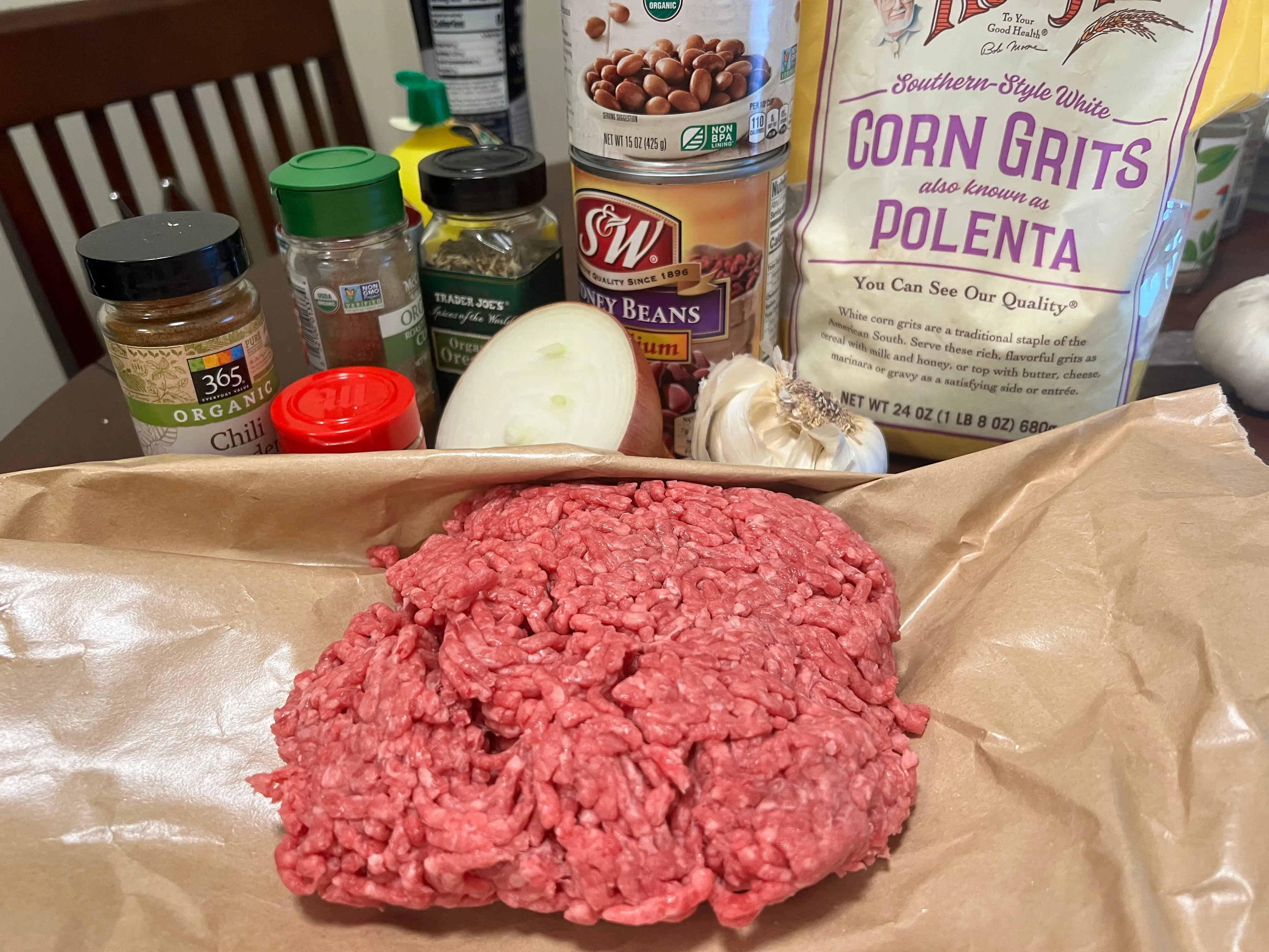 Ground beef, corn grits, and spices on table