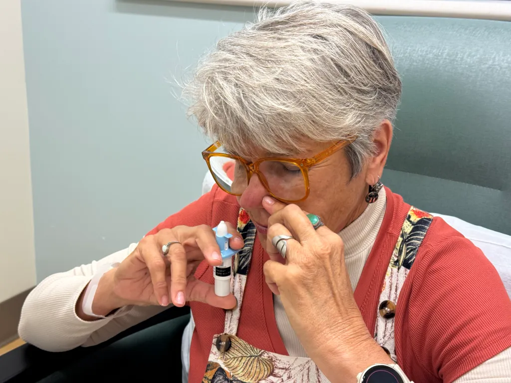A woman uses an Esketamine nasal spray treatment.