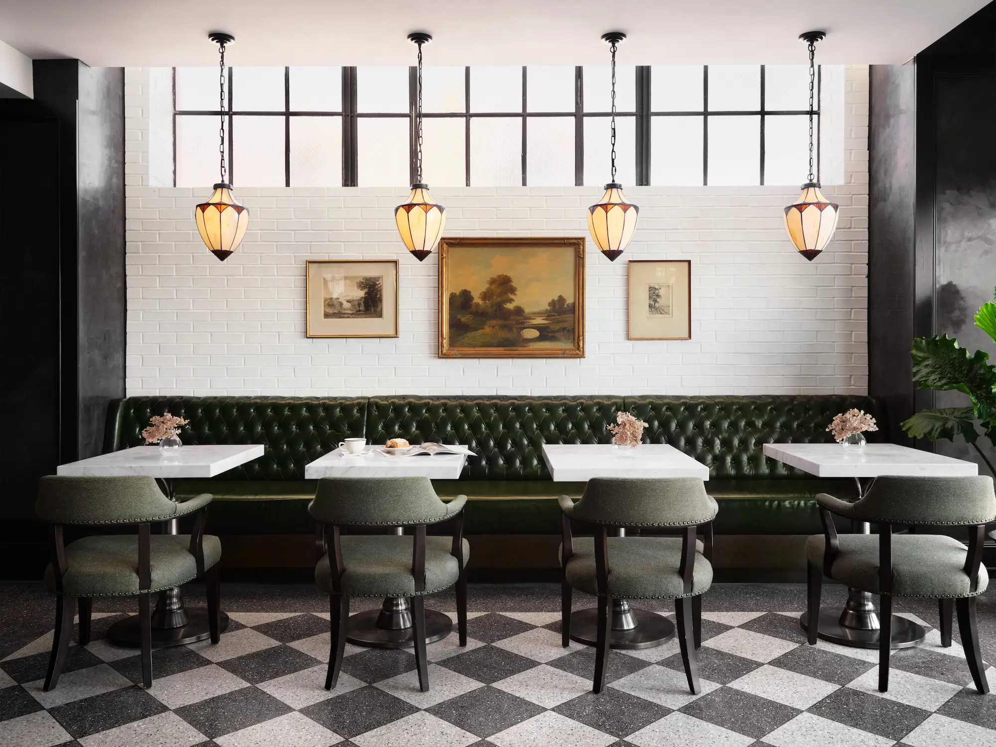 A dining area with checked floor and green booths.