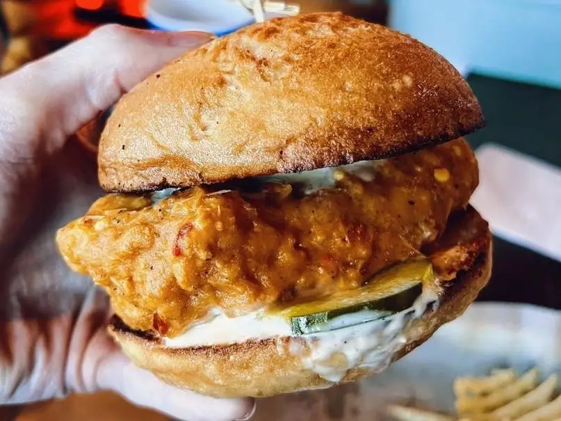 Someone holding a chicken sandwich.