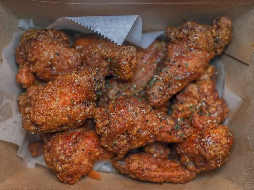 Seasoned fried chicken wings in a box.