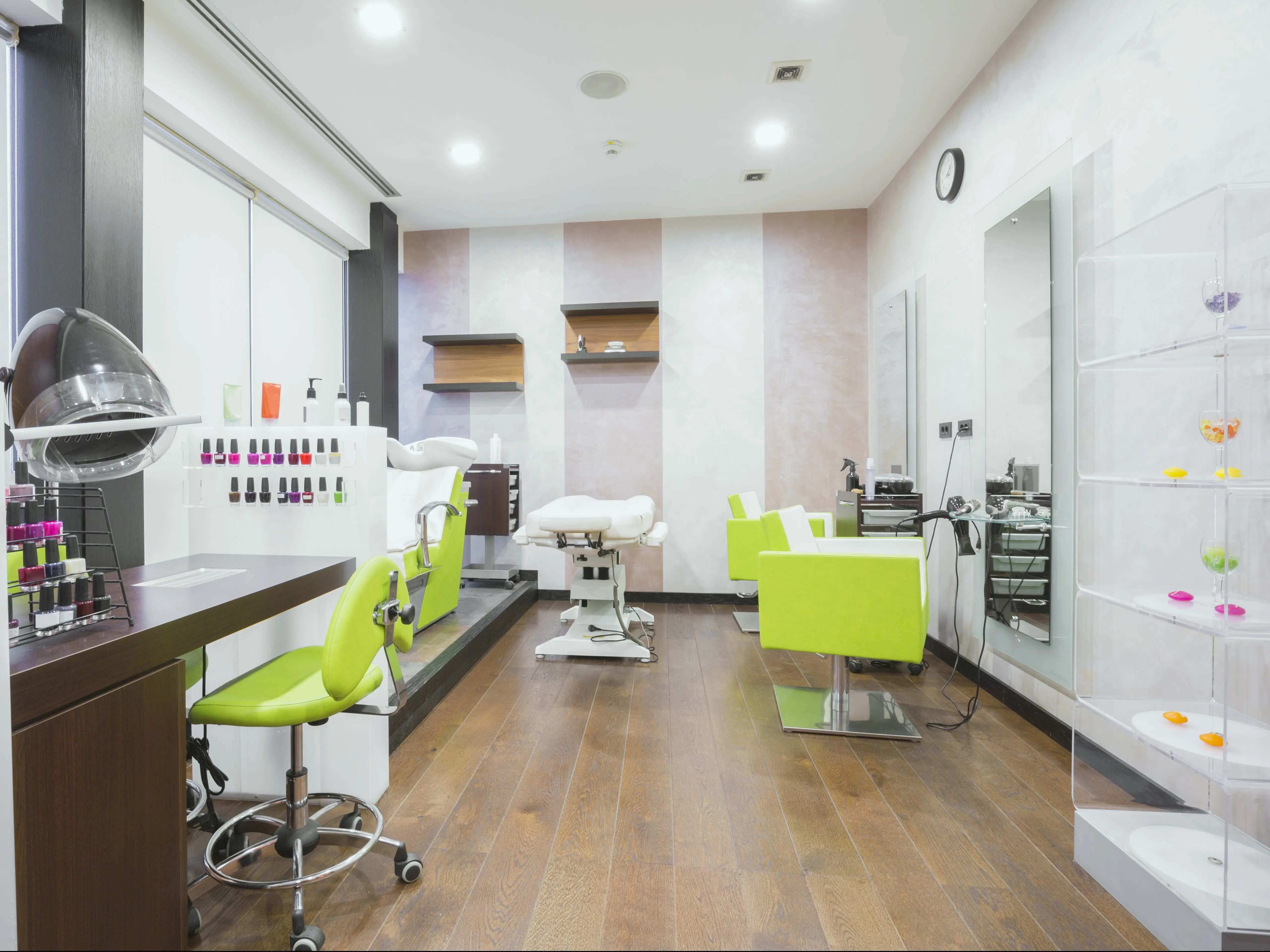 A spa with neon green chairs and various nail polish bottles.