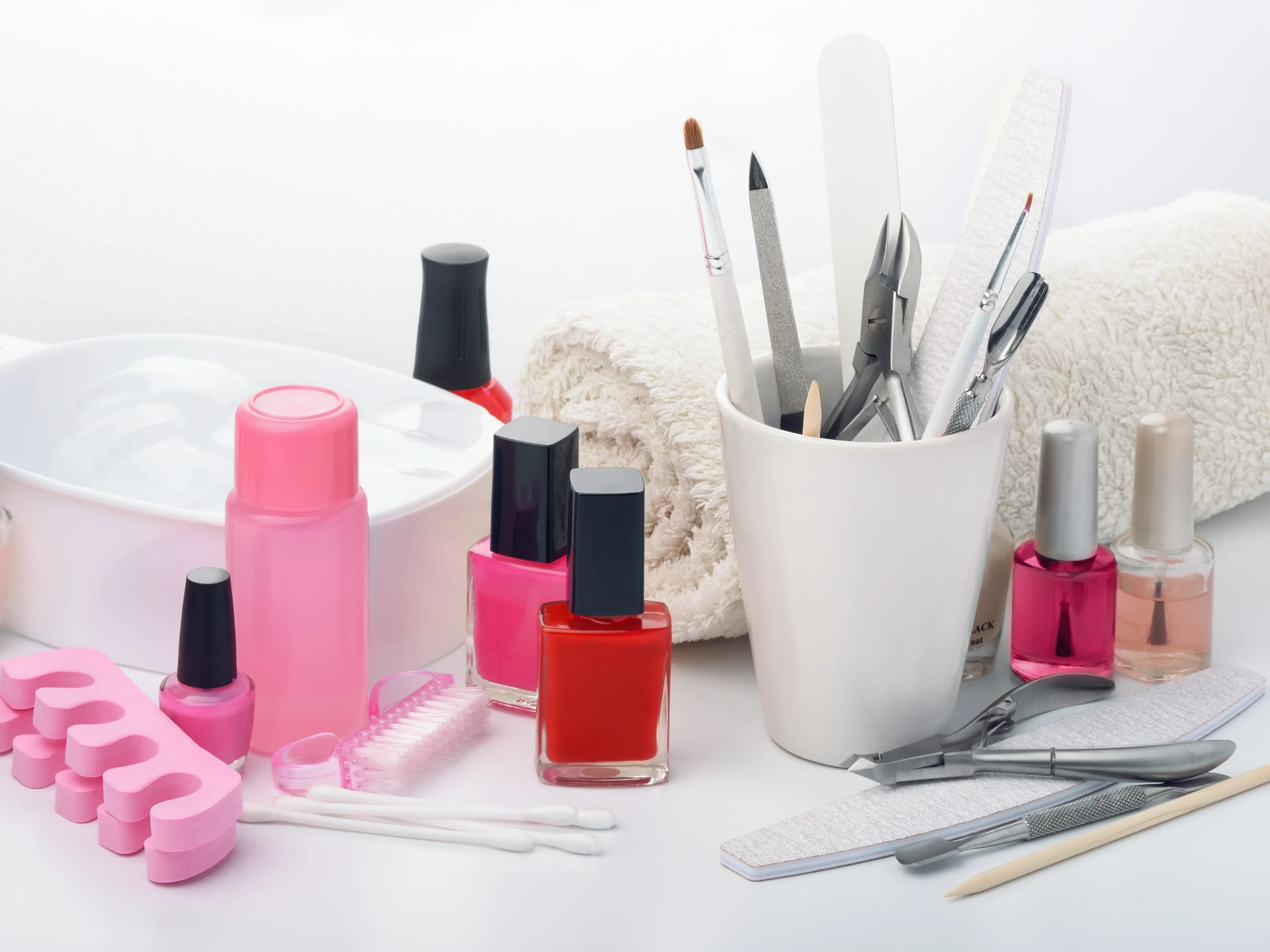 Manicure equipment, including nail polish and nail shaping tools, on a white table.