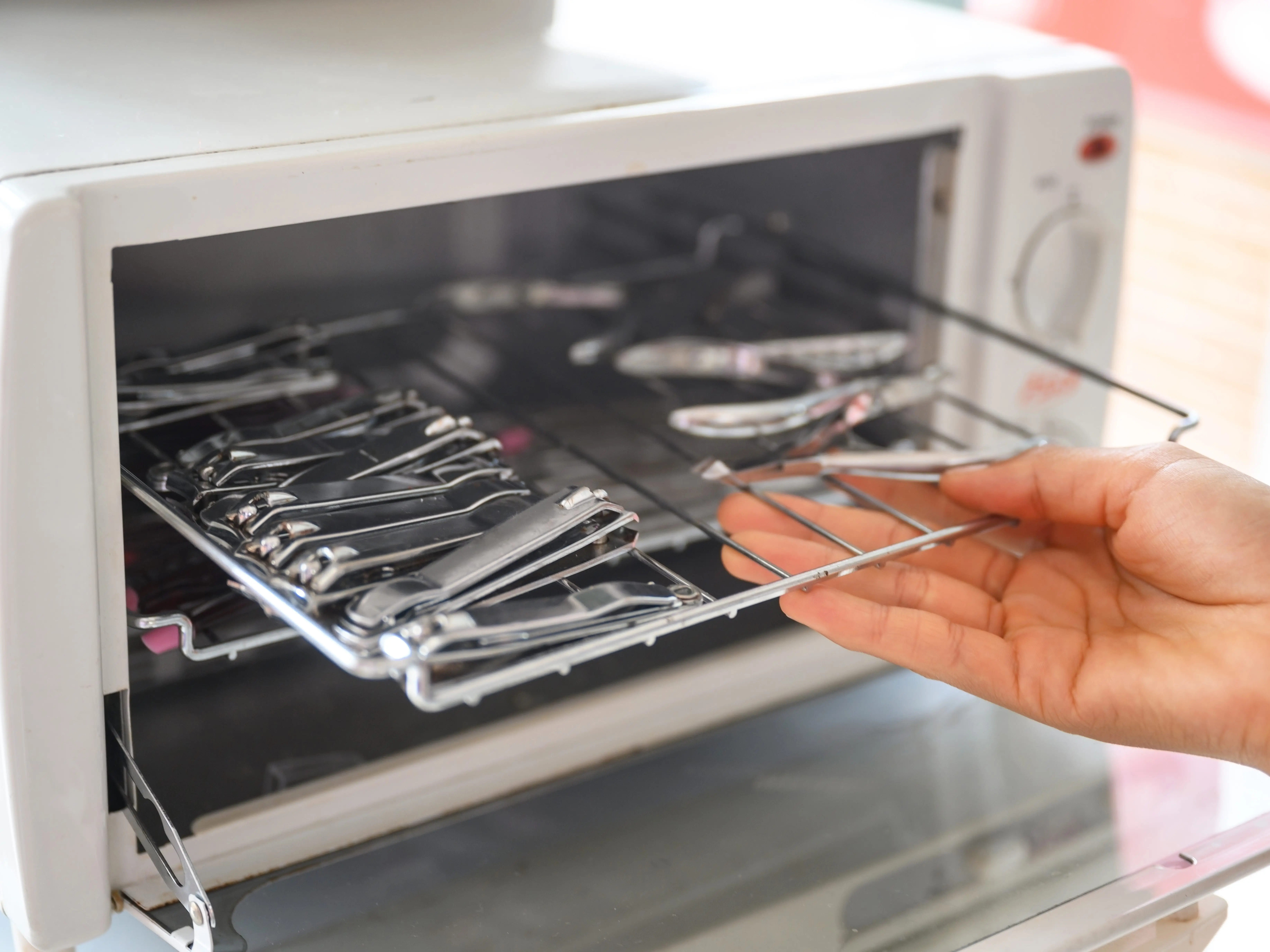A close-up of a female hand taking out sterilized nail equipment.