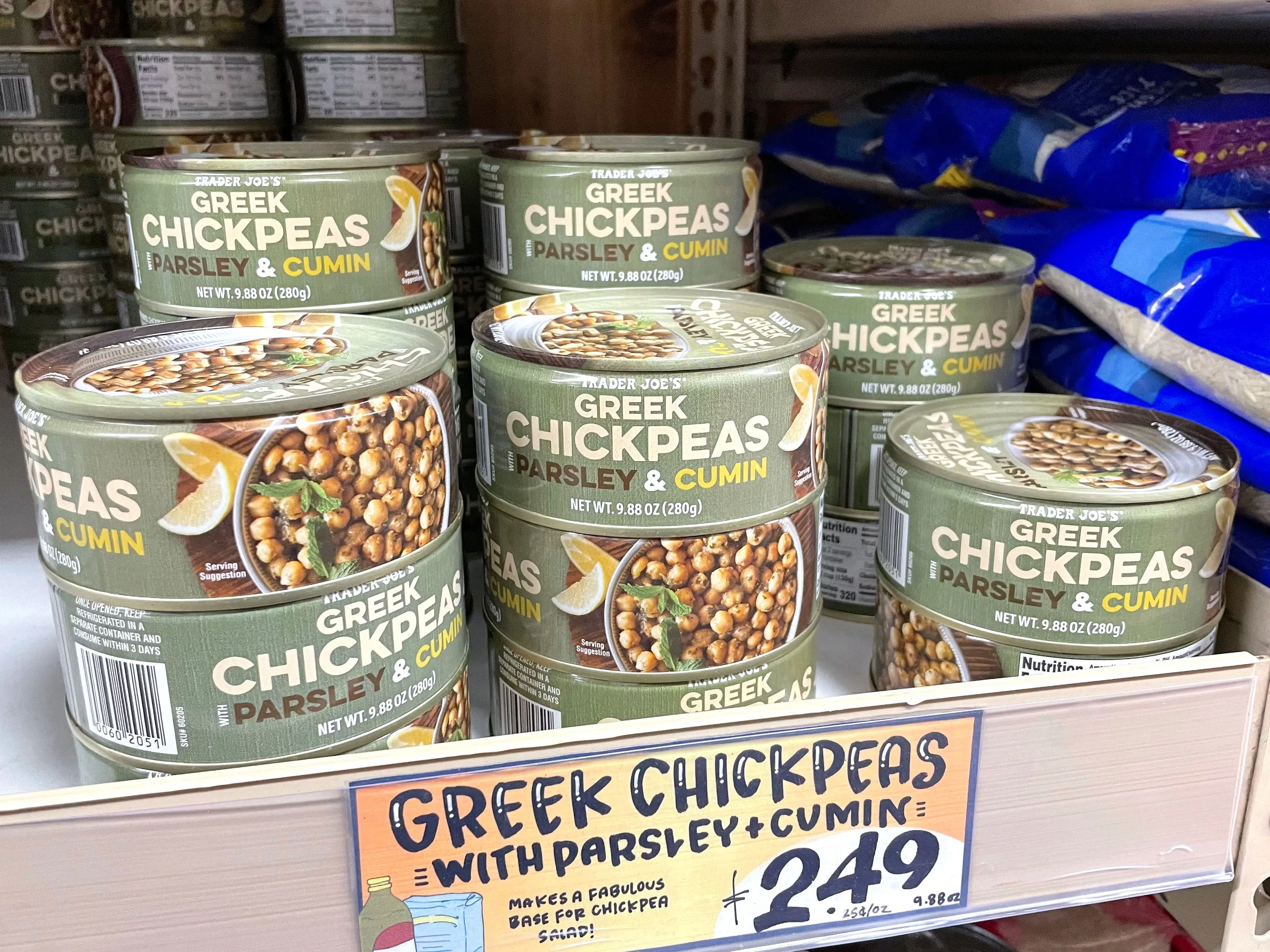 Stacked cans of Trader Joe's parsley-and-cumin Greek chickpeas with a price tag that reads $2.49.