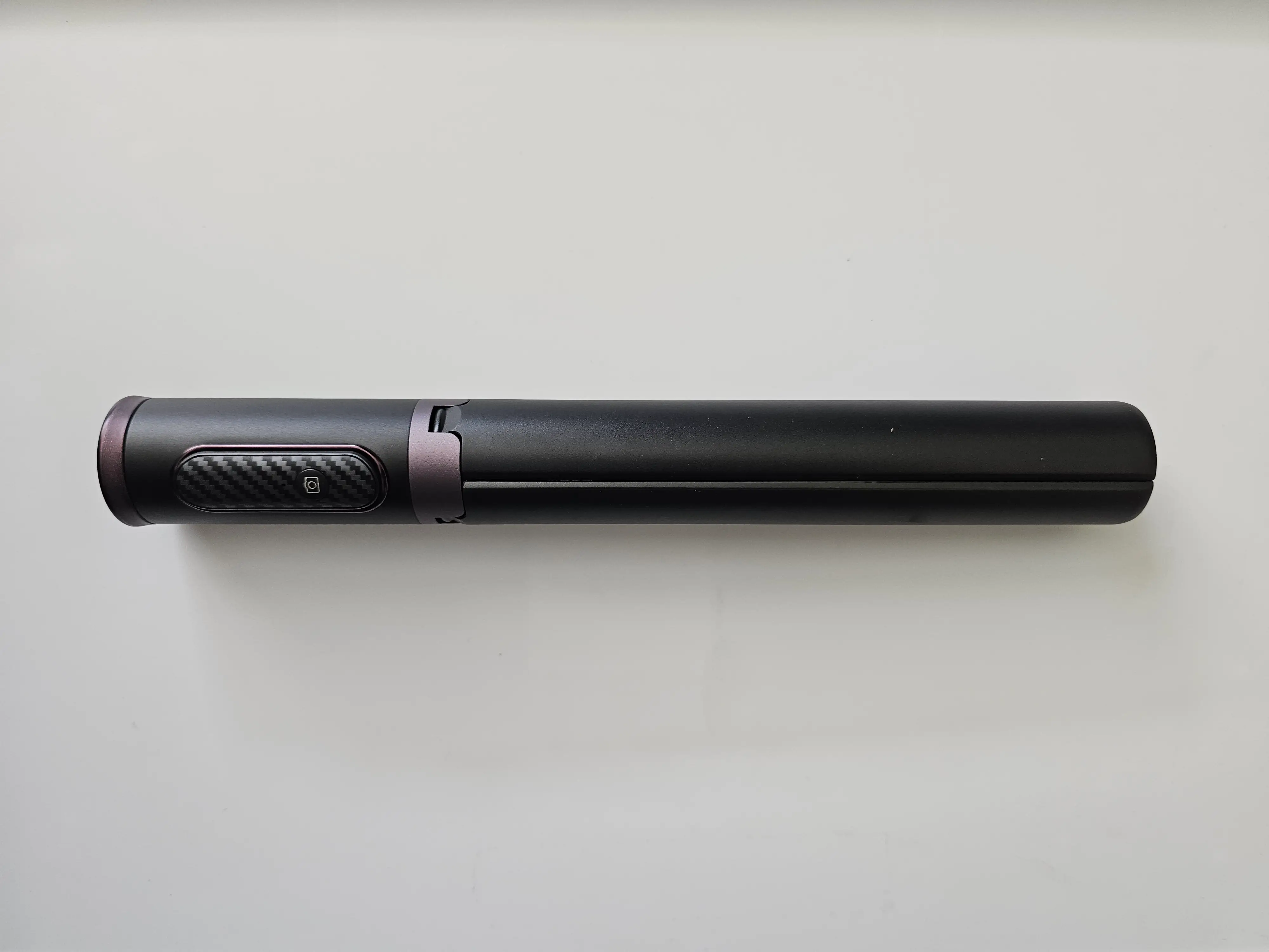 A black portable cellphone tripod folded up.
