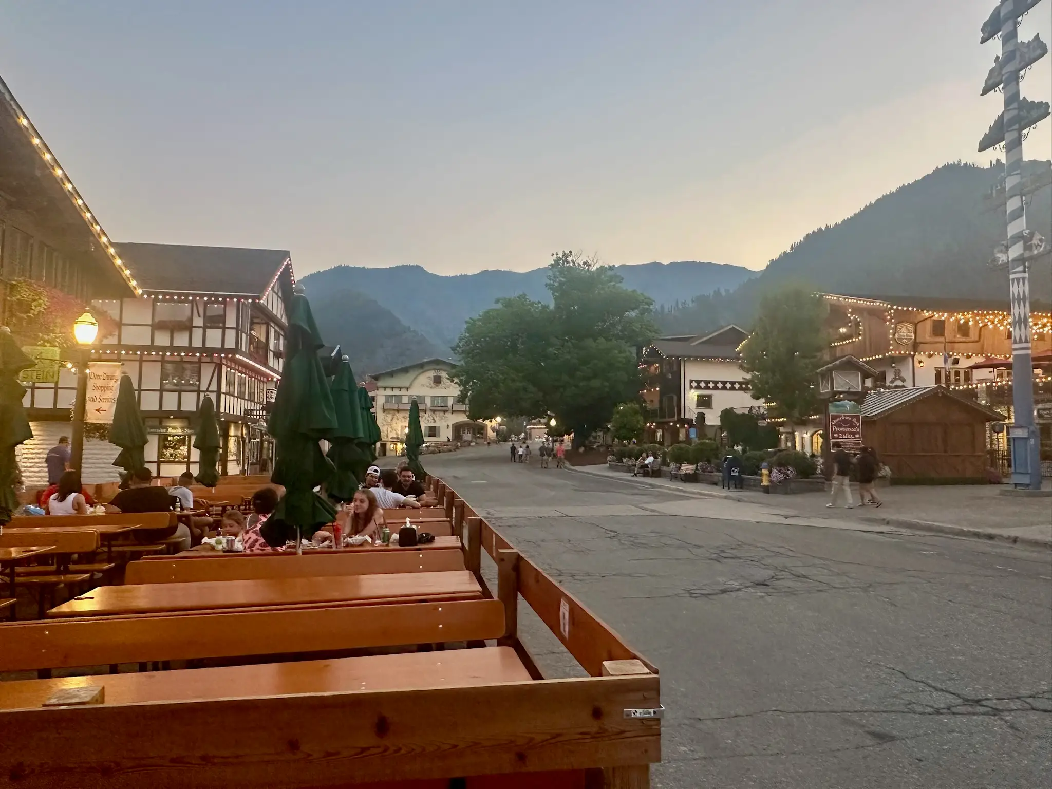 Outdoor beer garden with lit-up buildings behind it in Leavenworth.