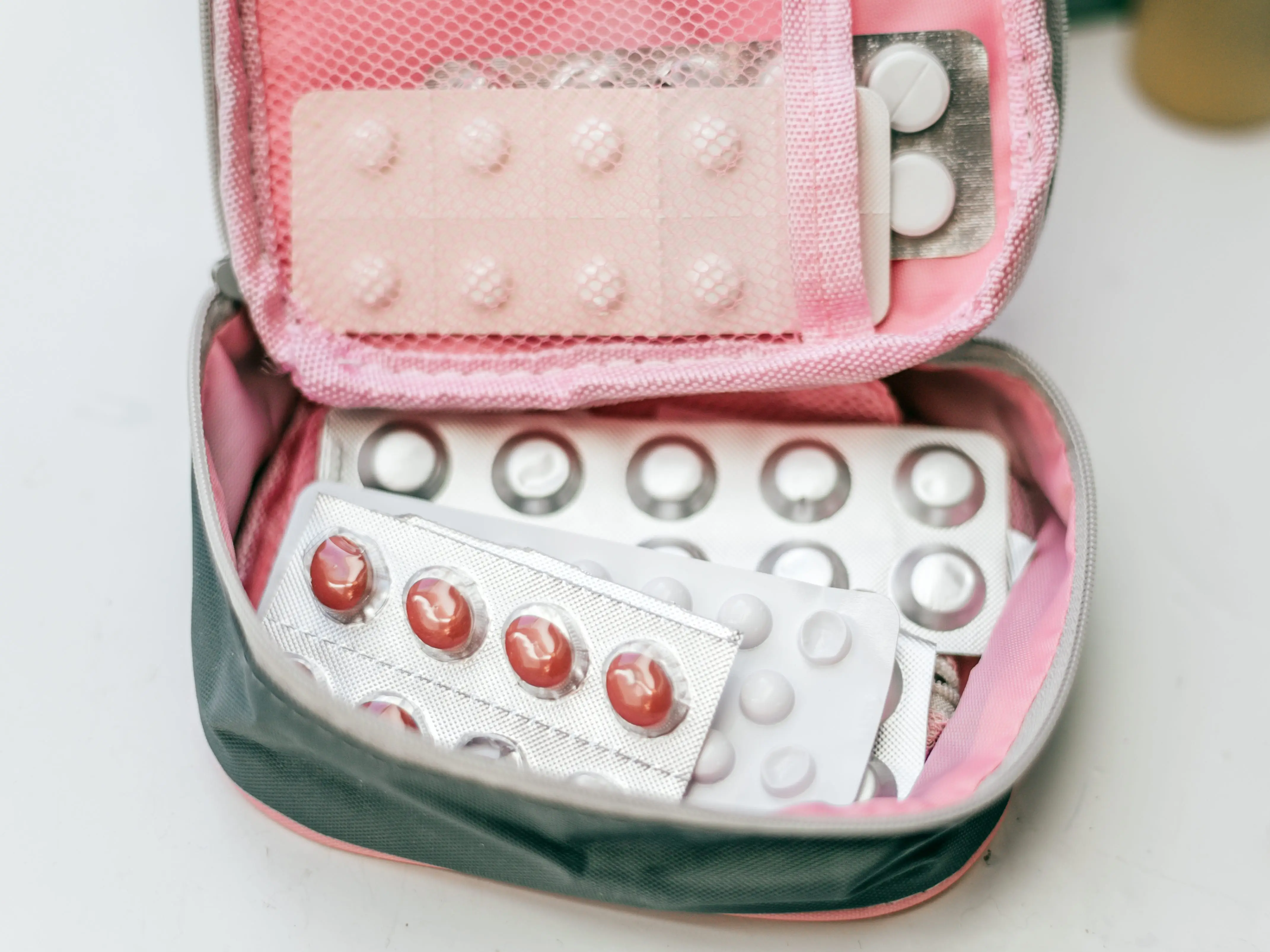 Multiple packs of pills in a small zip-up bag.