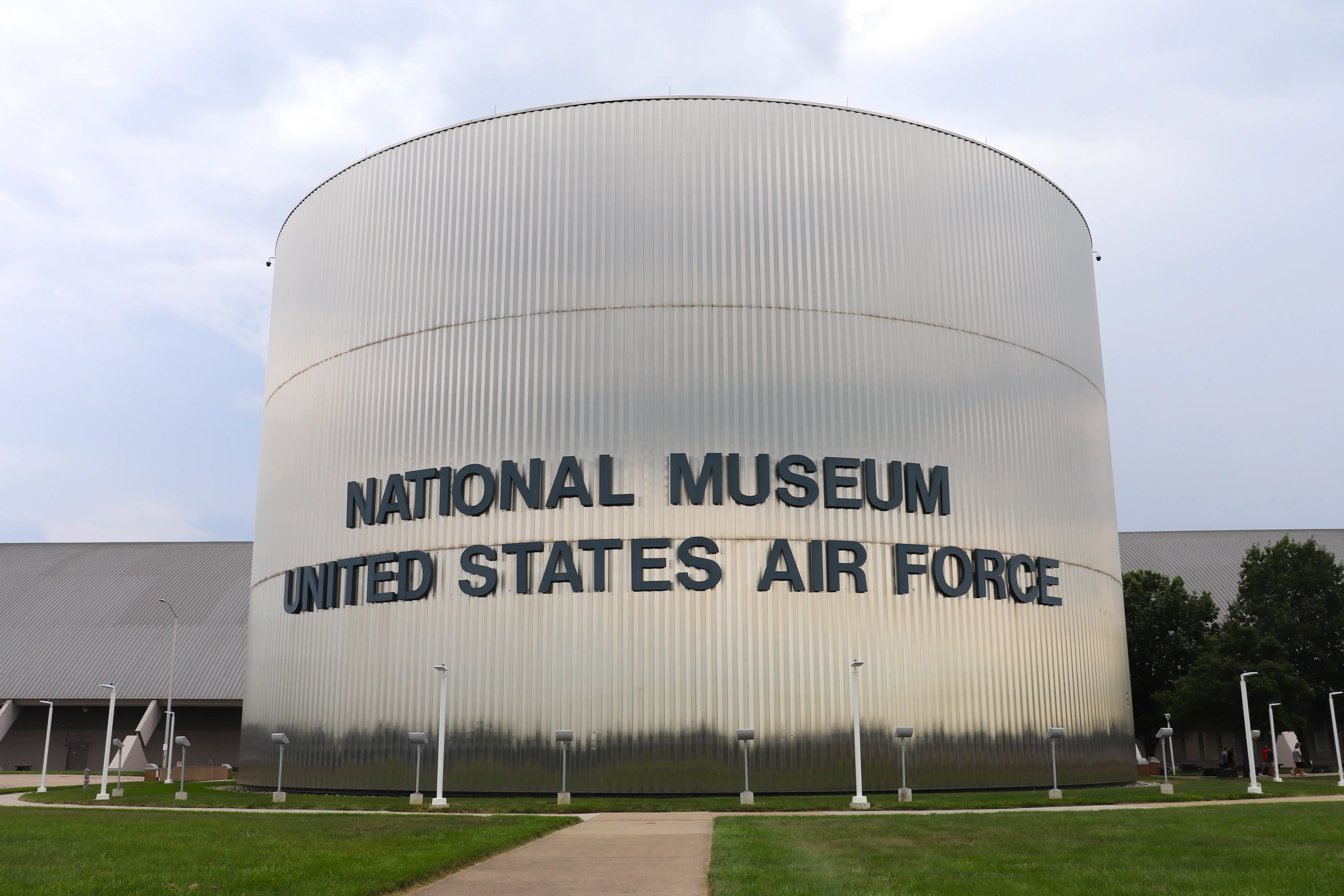 The exterior of the National Museum of the United States Air Force, with a column-shaped main building branded with the museum's name in bold black letters.