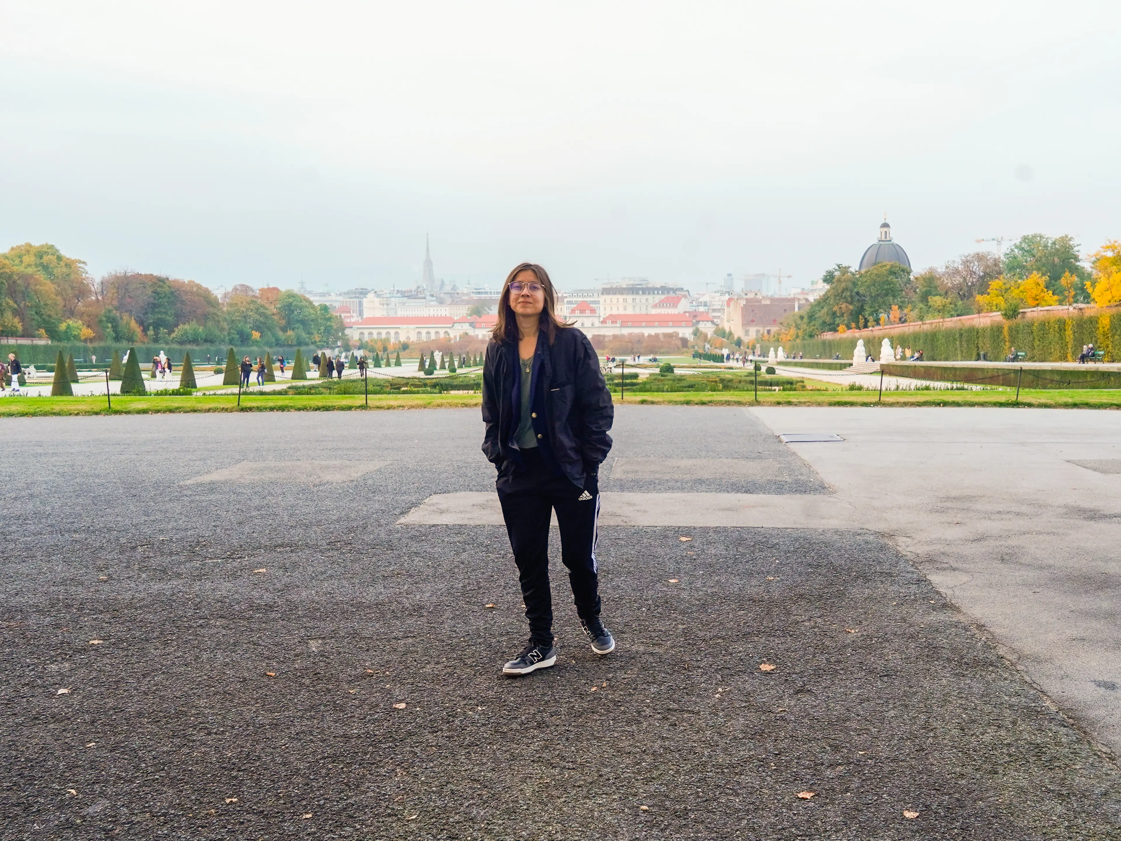 The author stands alone in front of a palace garden in Vienna