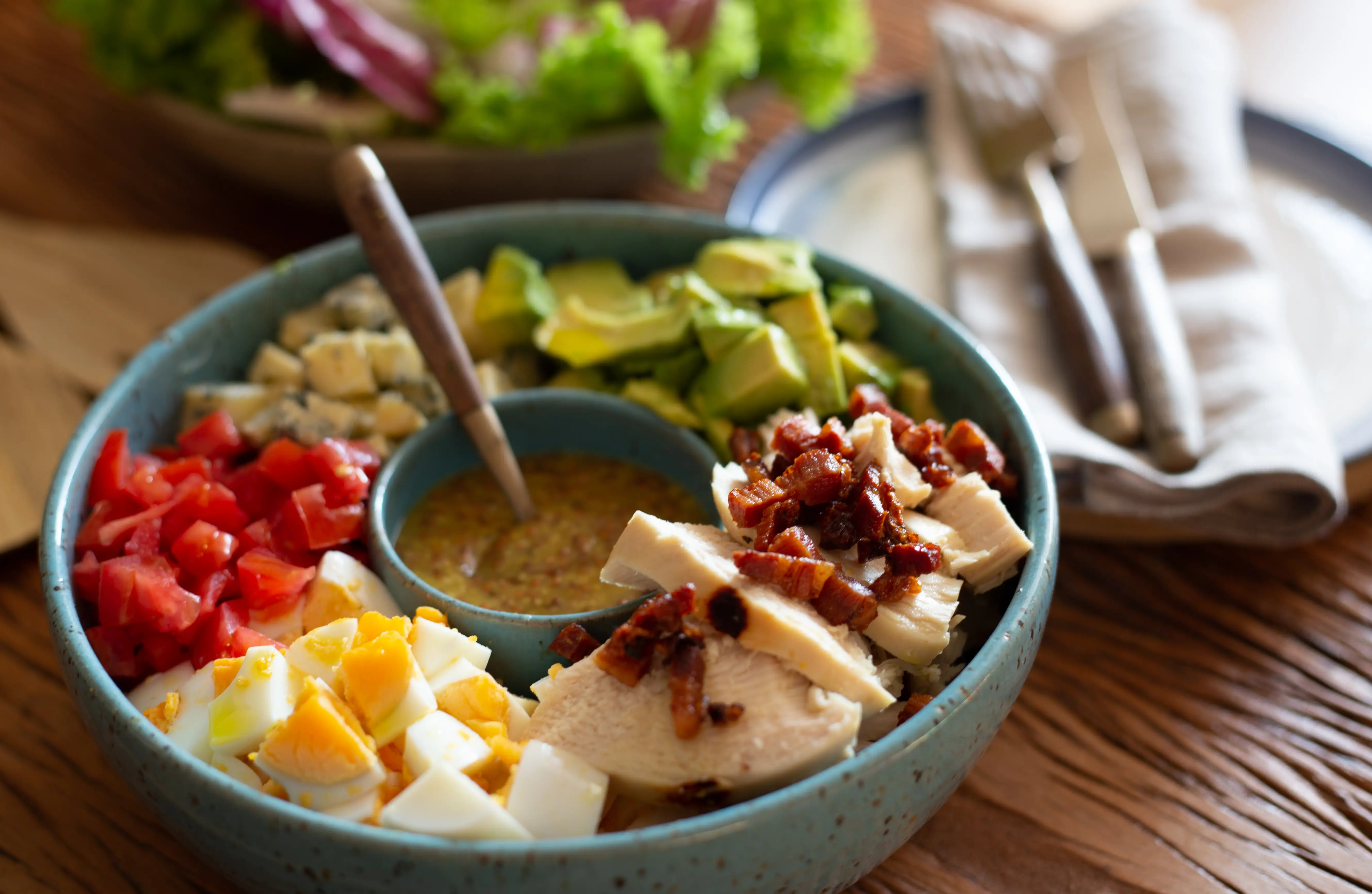 Chicken, hard-boiled egg, tomato, in bowl with dressing in center