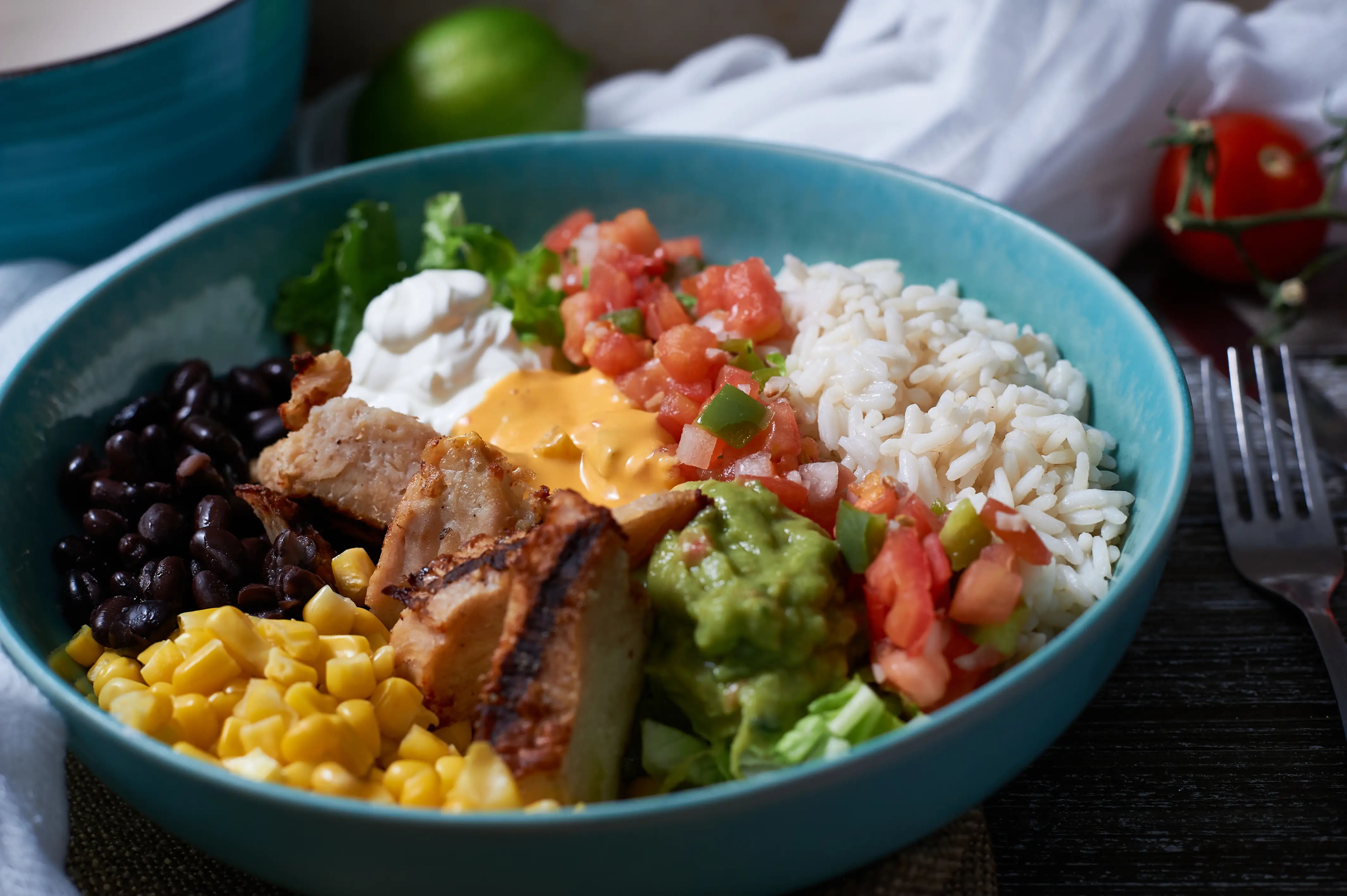 Rice bowl with chicken, tomato, avocado, corn, beans