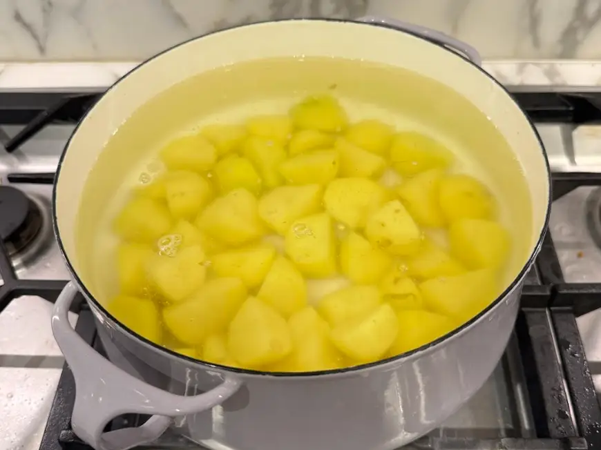 The potatoes cooking on a stovetop.