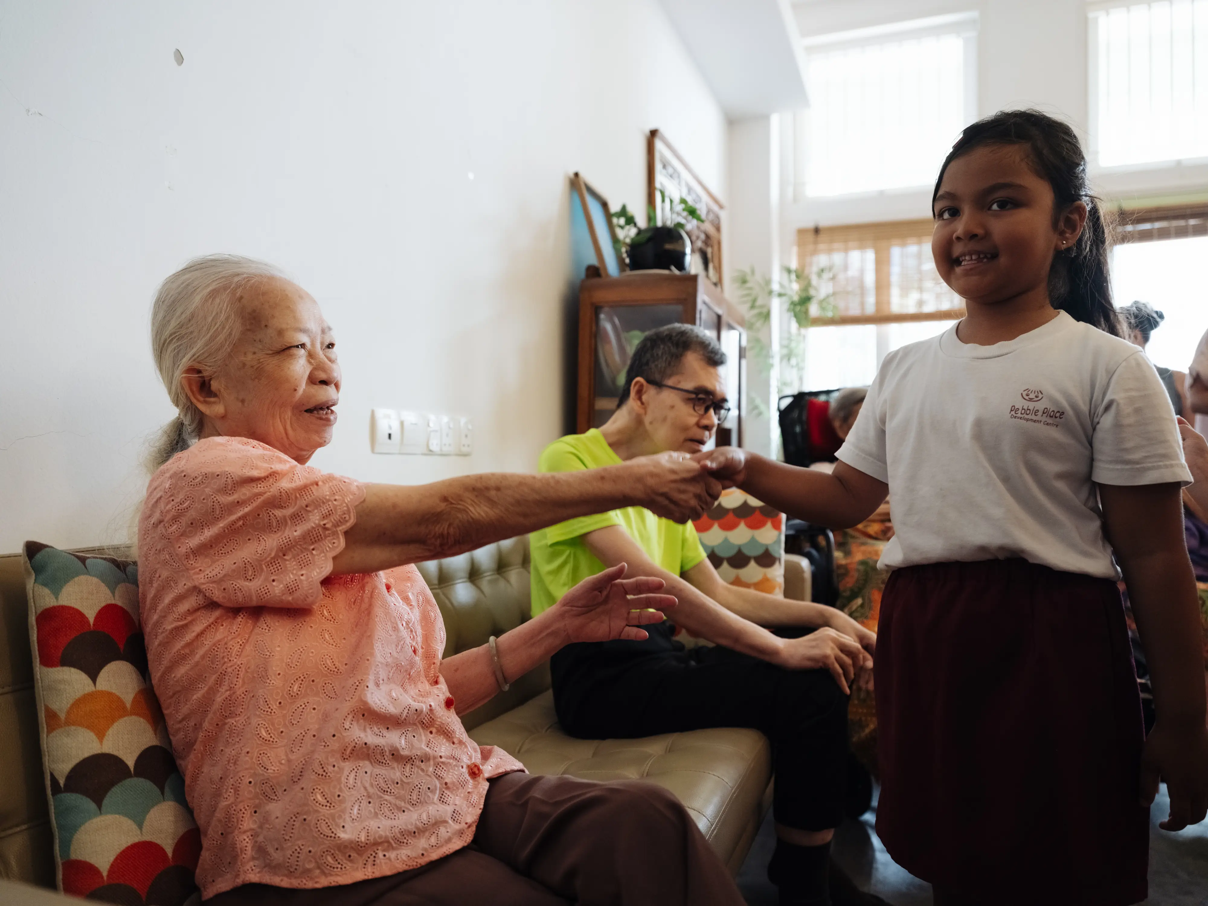 A woman shakign hands with a kid.