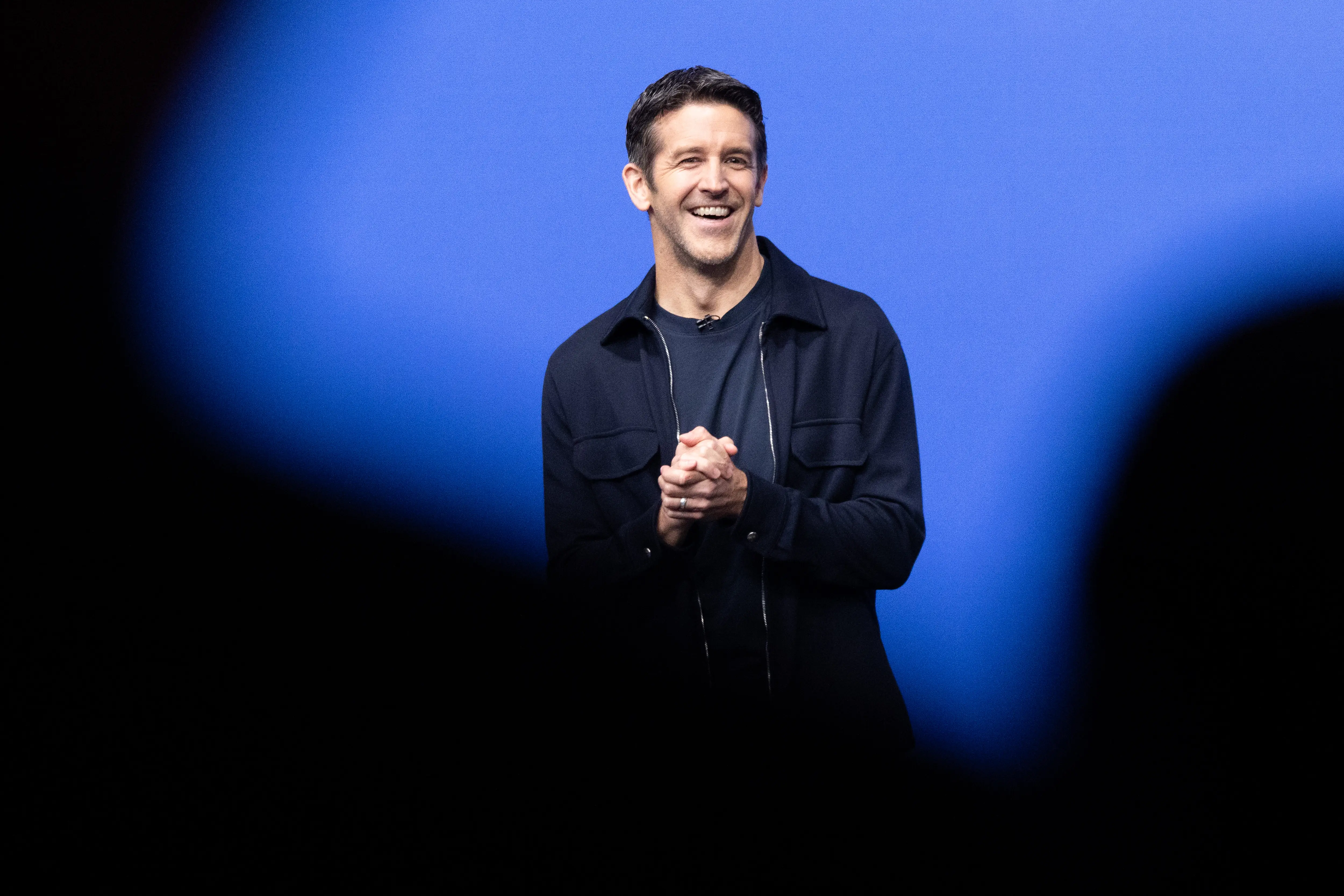 Apple CEO, John Ternus, clasps his hands onstage during a recent product launch.