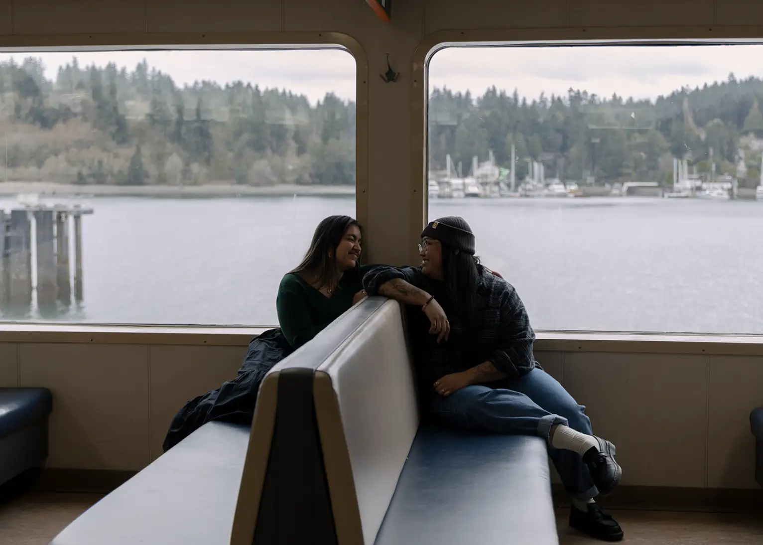 The writer and her wife sitting across from each other on a ferry, gazing into each other's eyes.