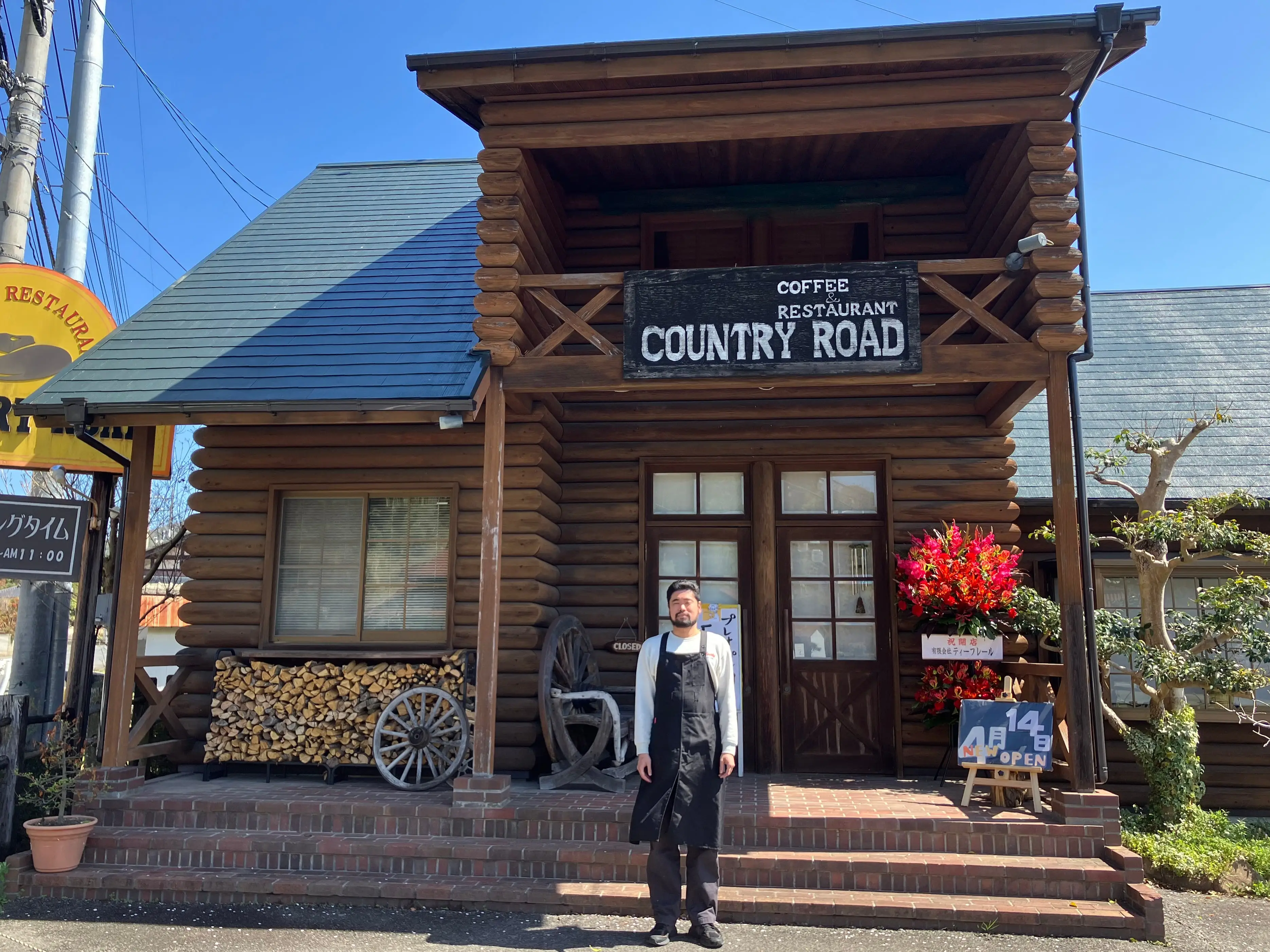 A man is posing outside the cafe.