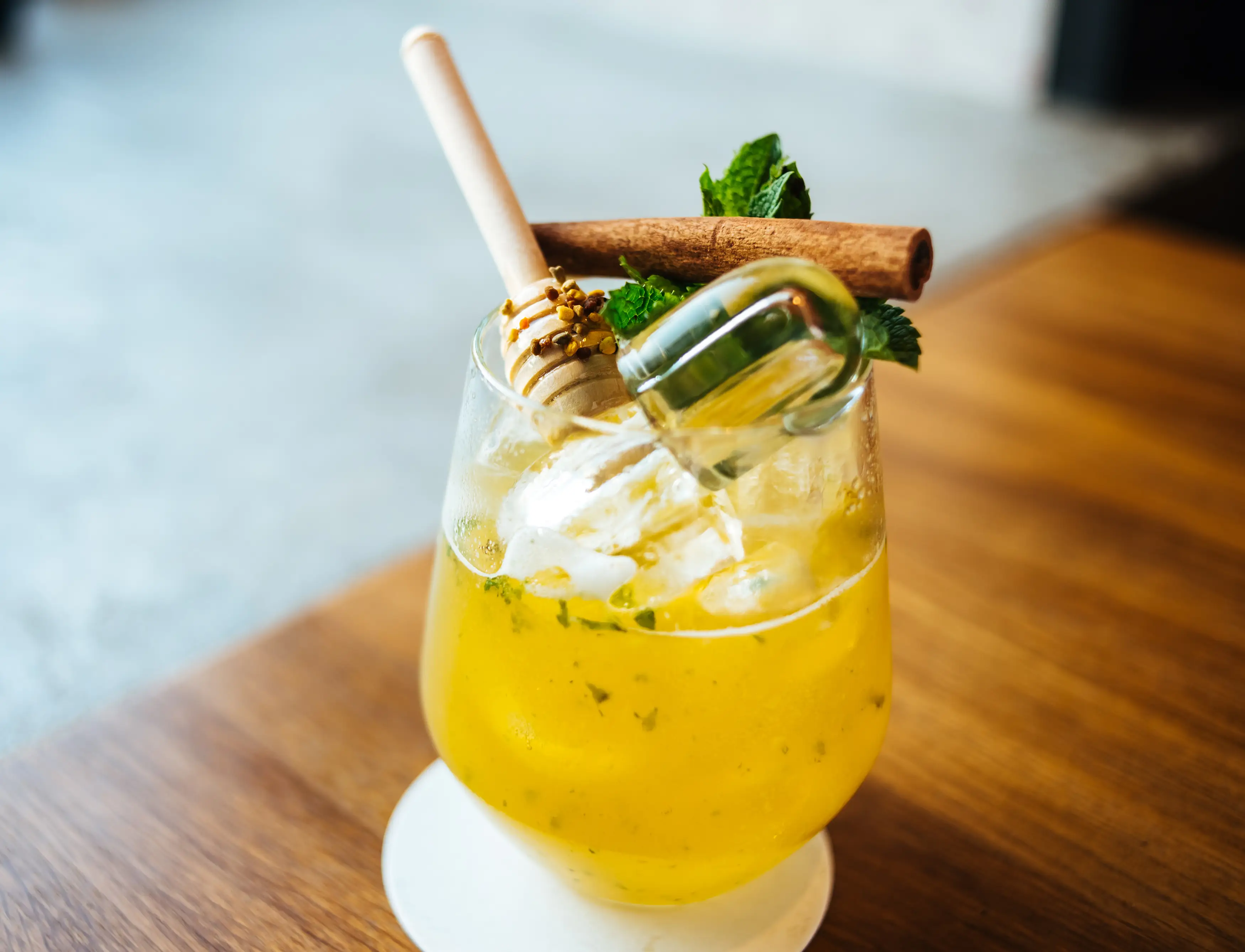 Cocktail with mint, cinnamon stick, honey dropper, pollen