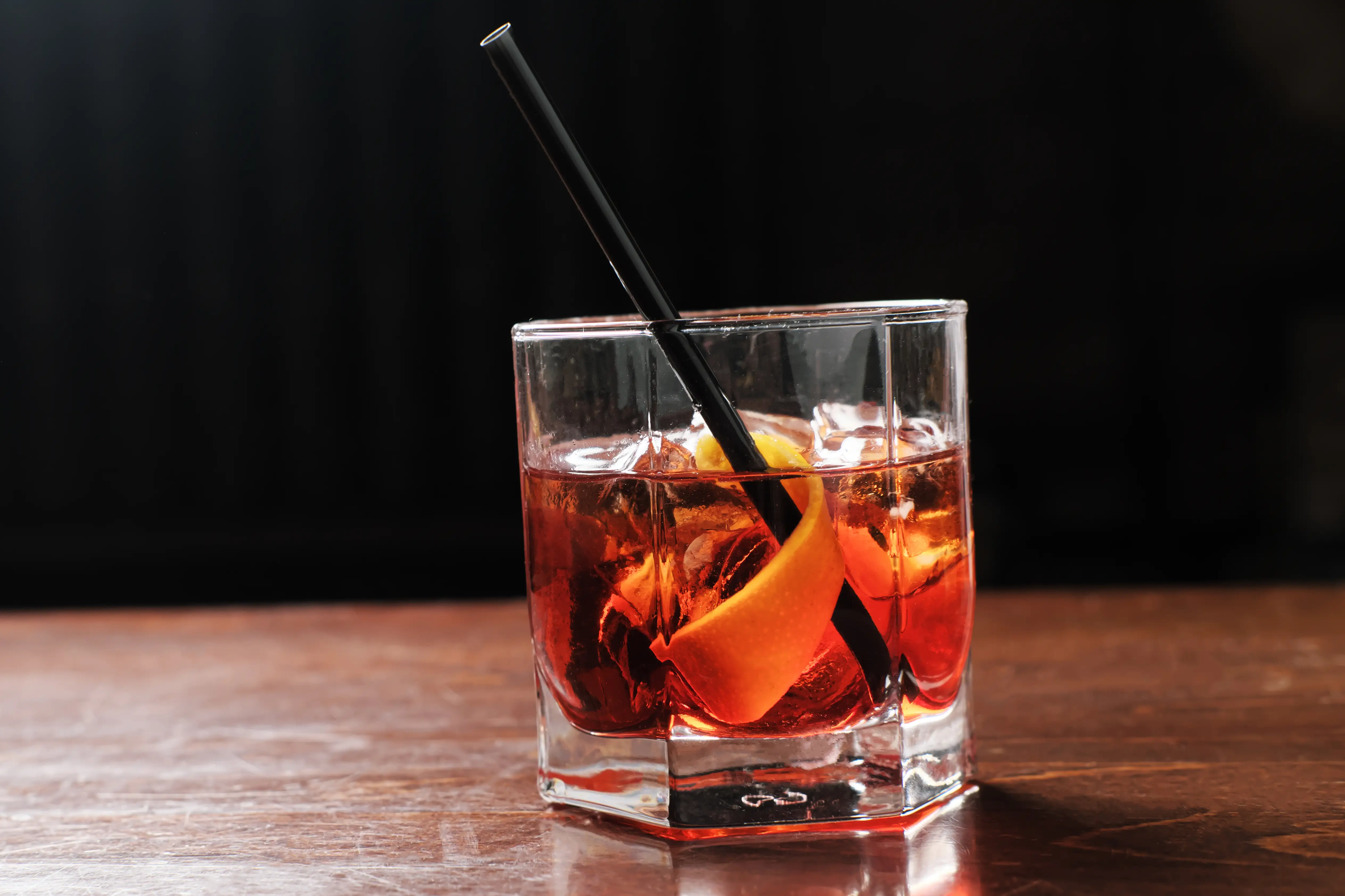 Boulevardier cocktail with fruit rind, ice