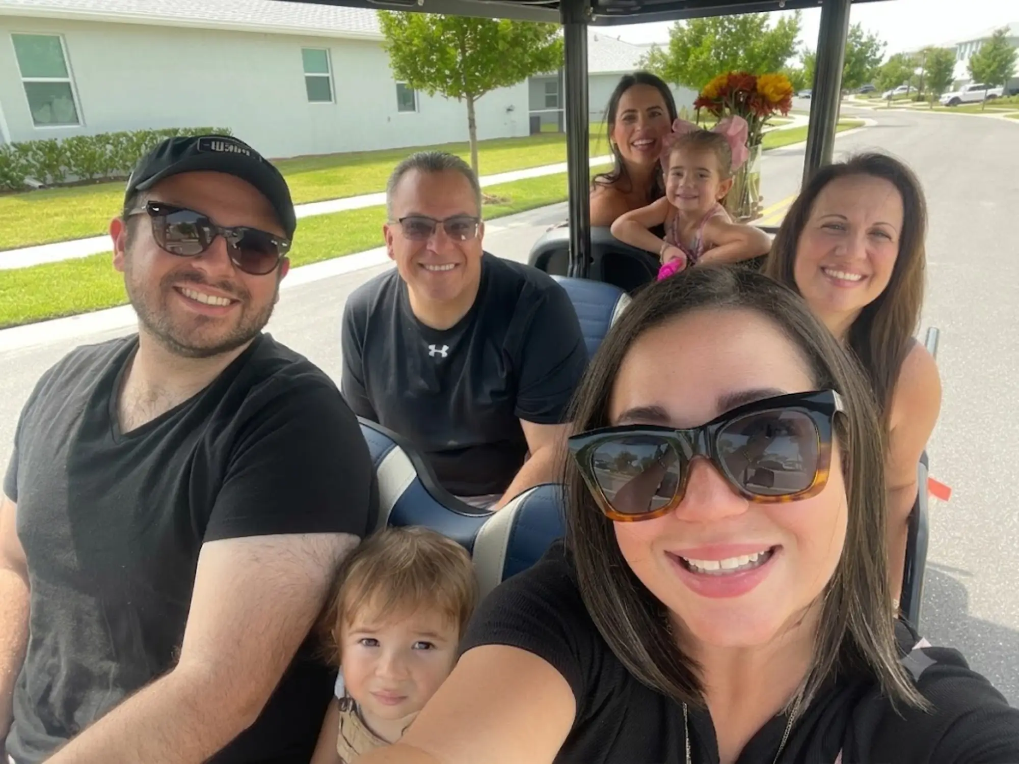 Group of people smiling on golf cart