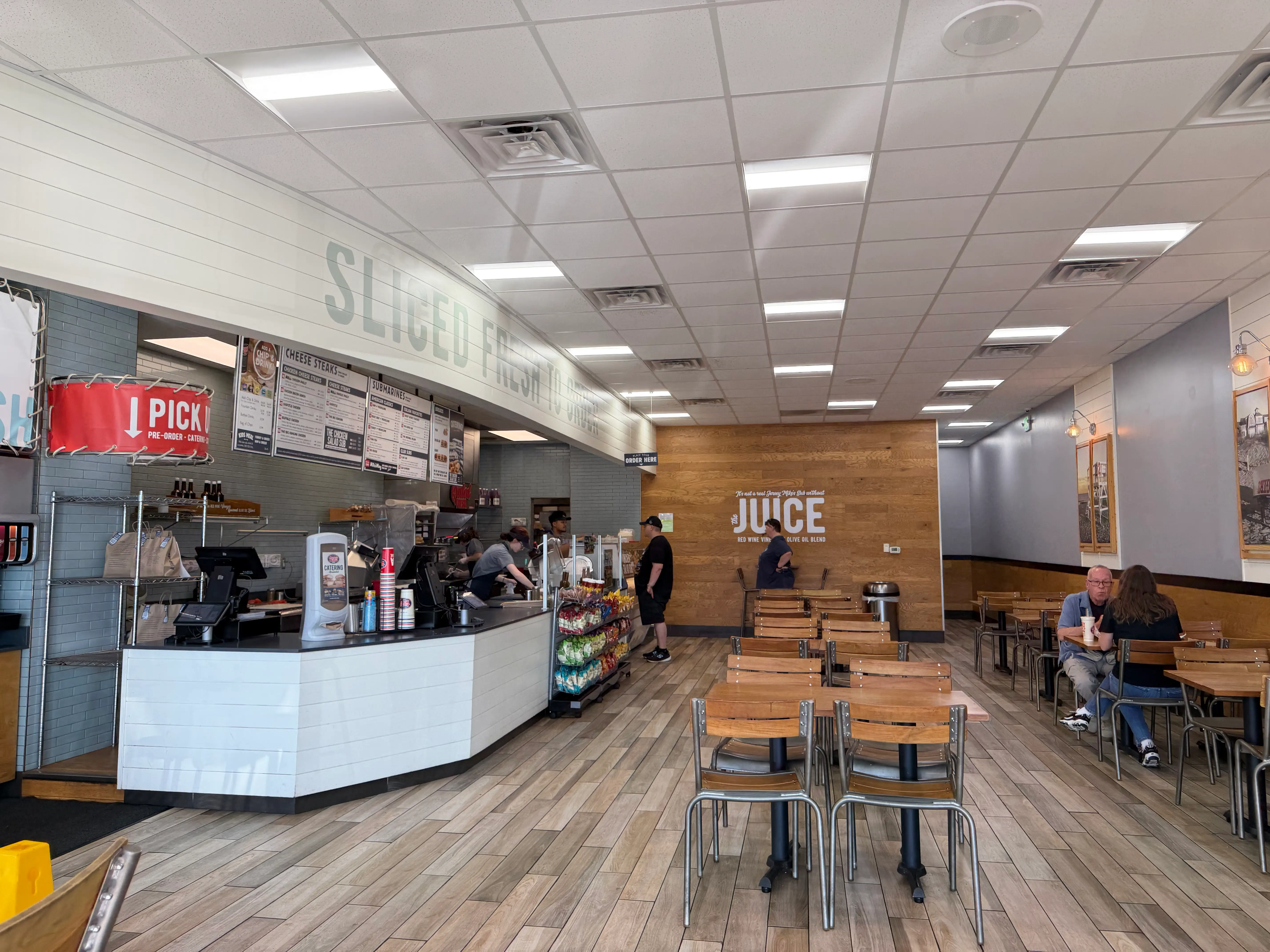 interior of jersey mikes with seating, a few people inside