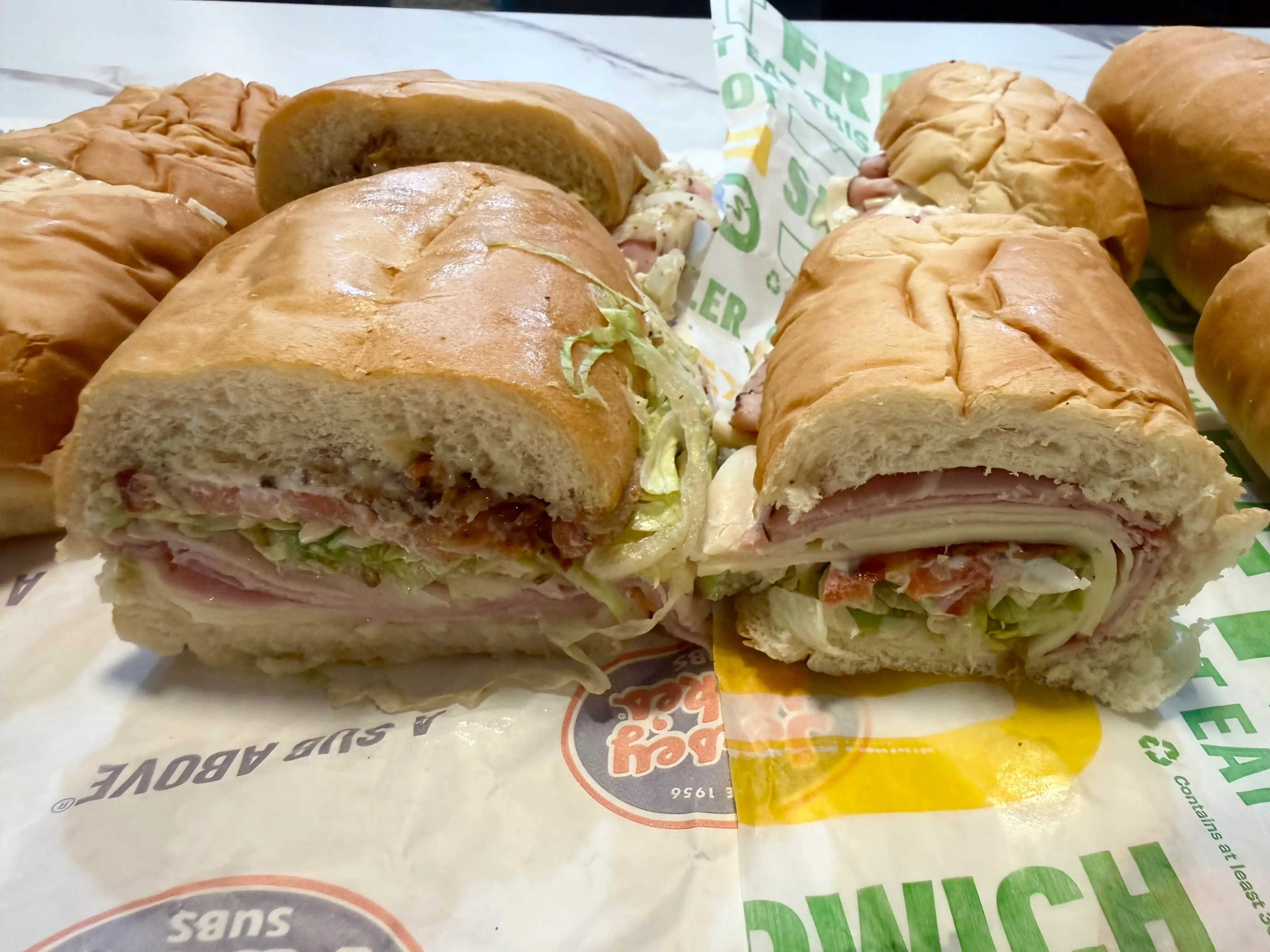 Side by side of Jersey Mikes and Subway club sandwich half