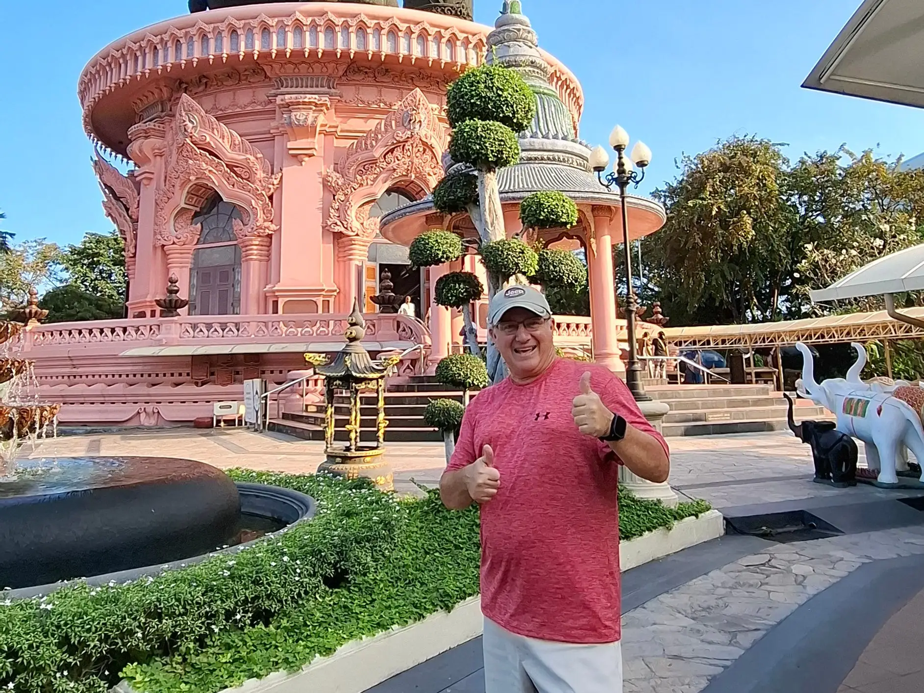 A man posing with a statue.