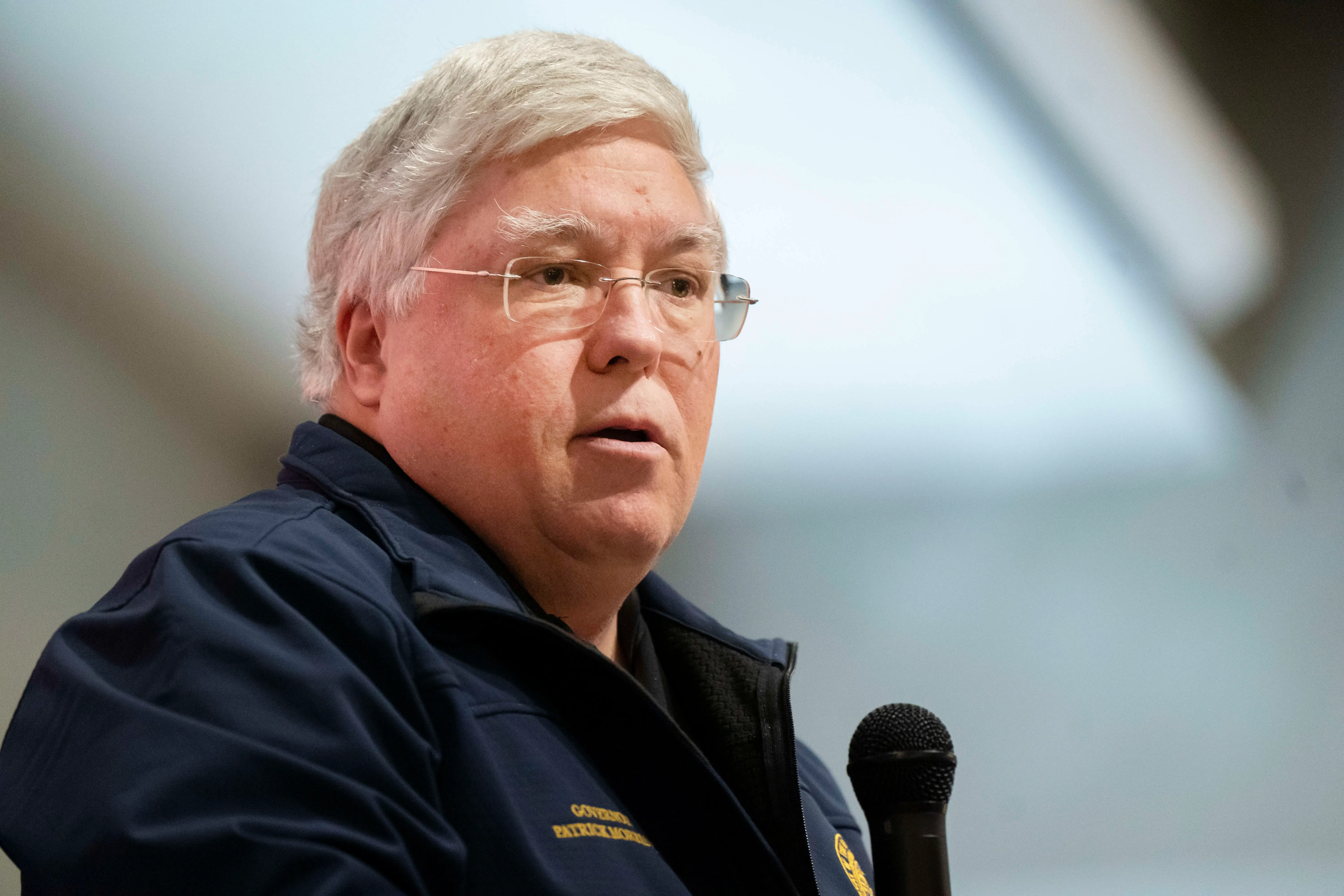 A man in a navy jacket speaks.