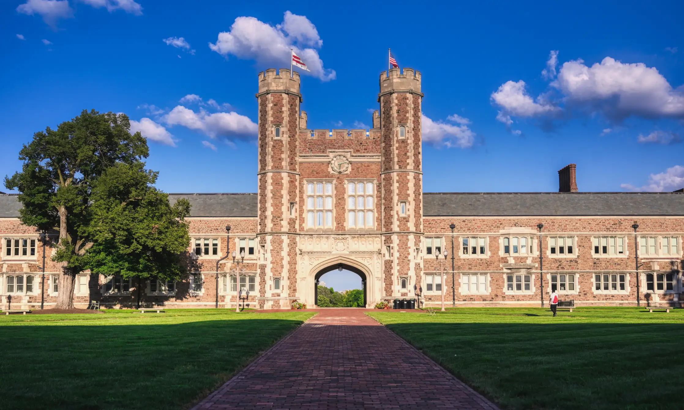 Brookings Hall at Washington University in St. Louis stands behind a brick walkway and green campus lawn.
