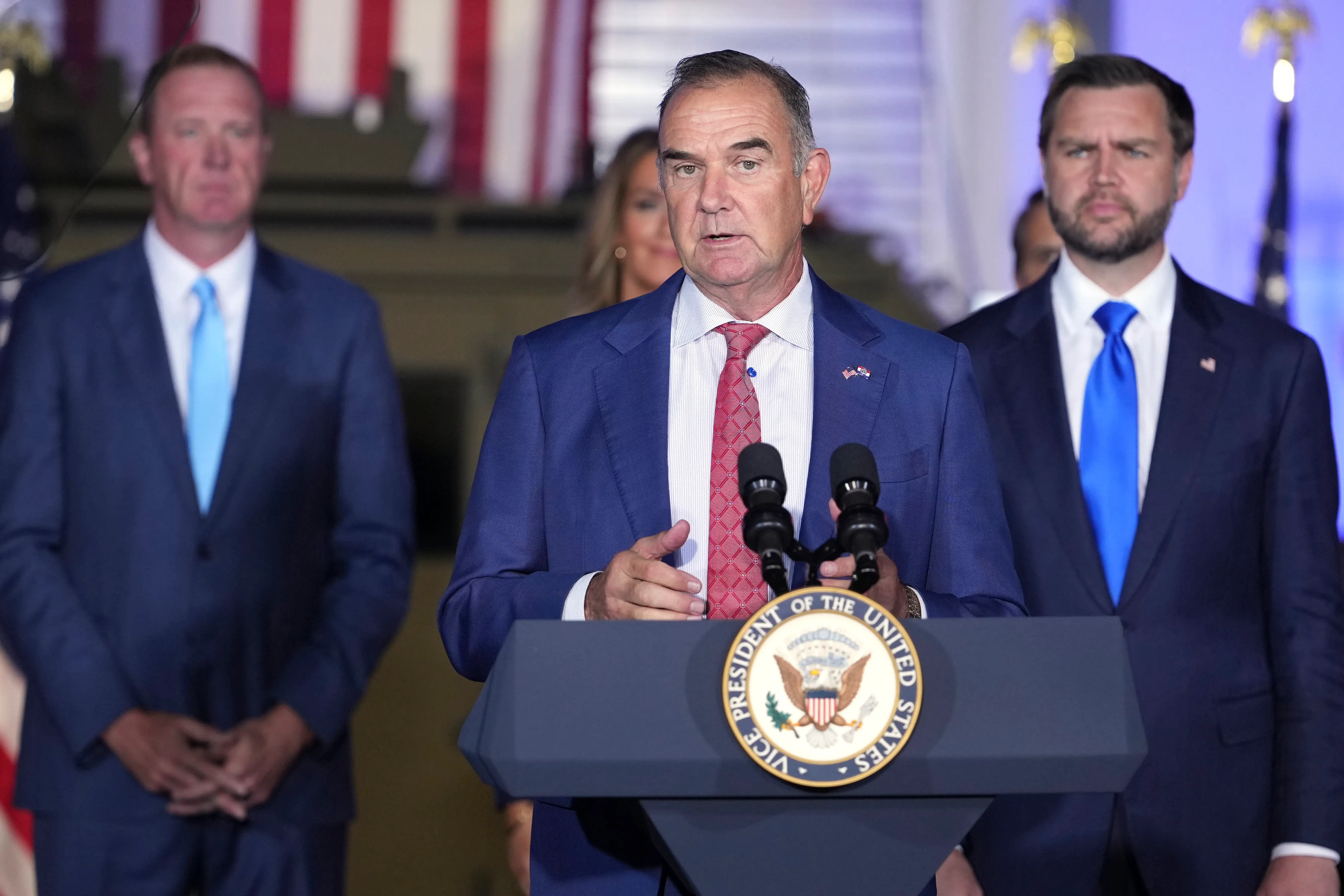 A man in a suit speaks.