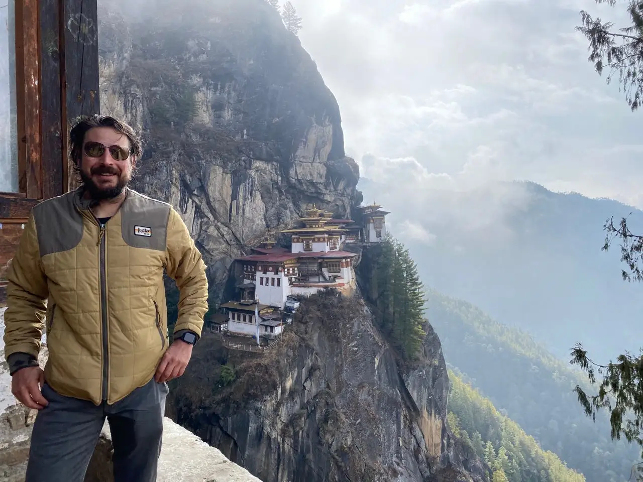Man posing with Bhutan Tiger Nest Monastery in background