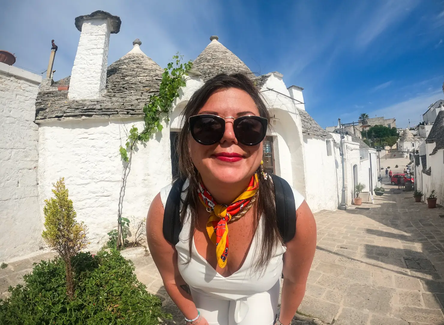 The writer standing in front of white houses in Alberobello.