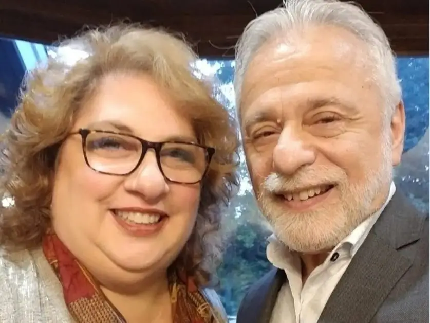 A husband and wife are taking a selfie.