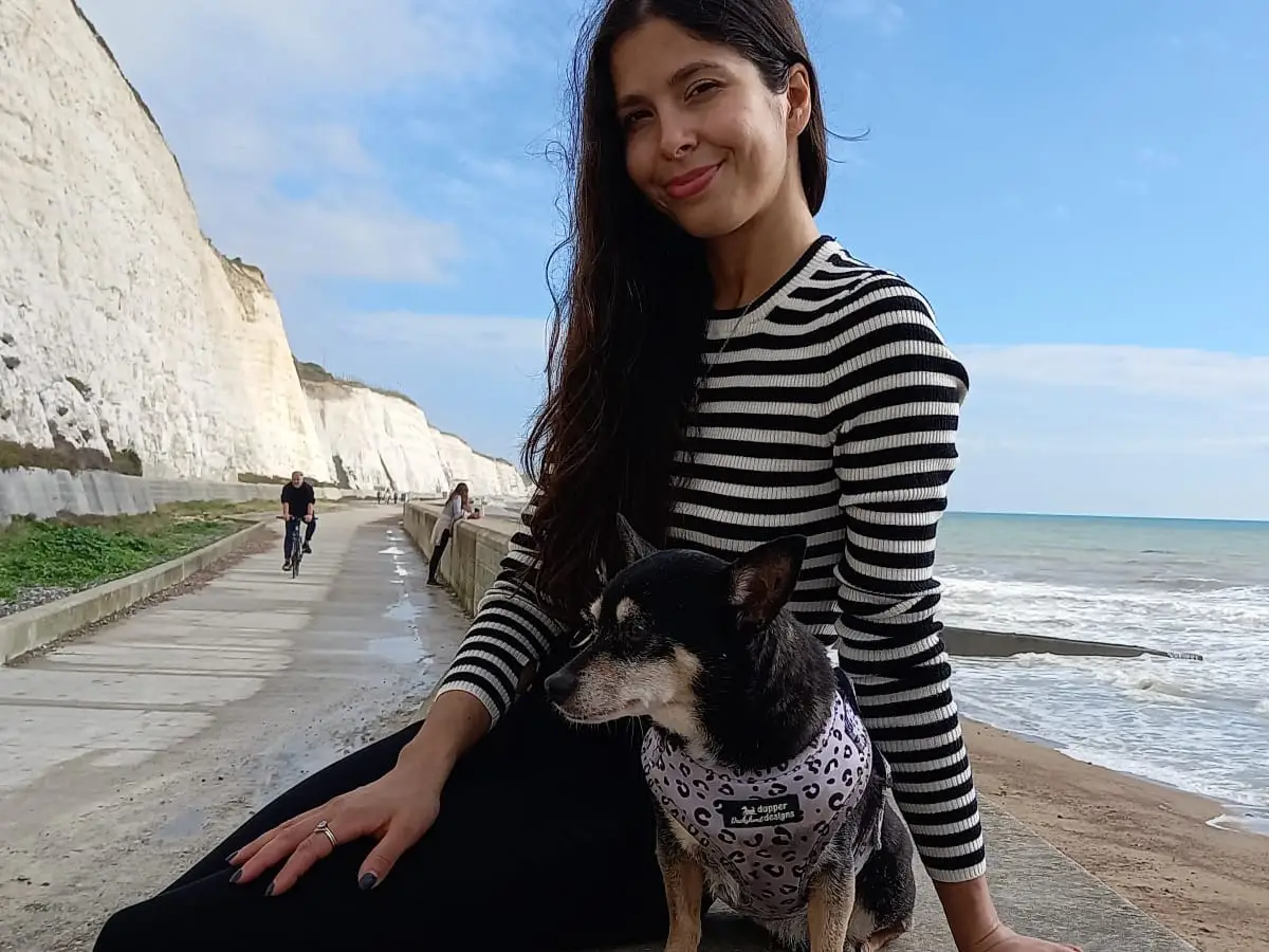 the author and her dog sitting by the beach