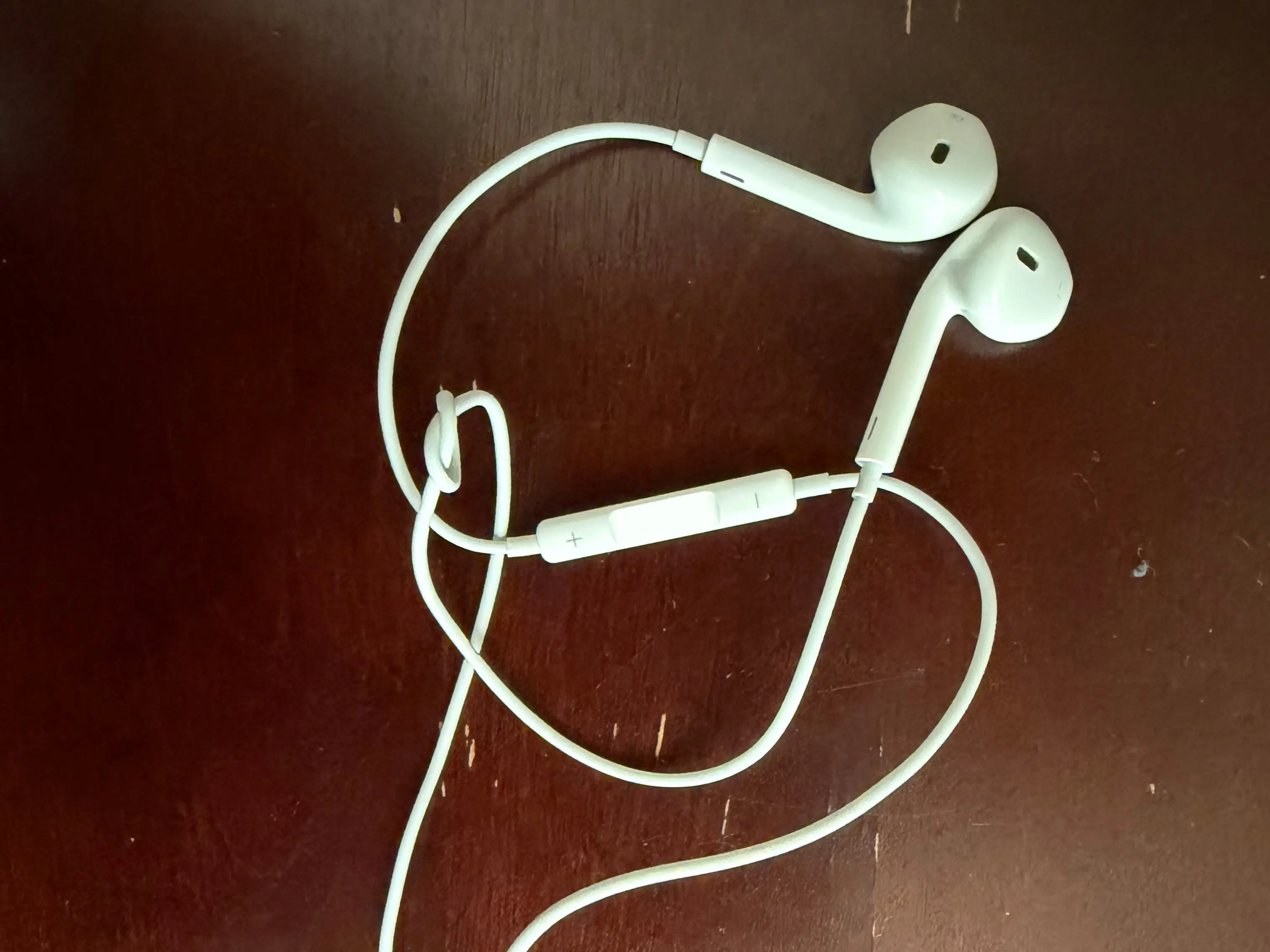 The writer's wired headphones sit on a table.
