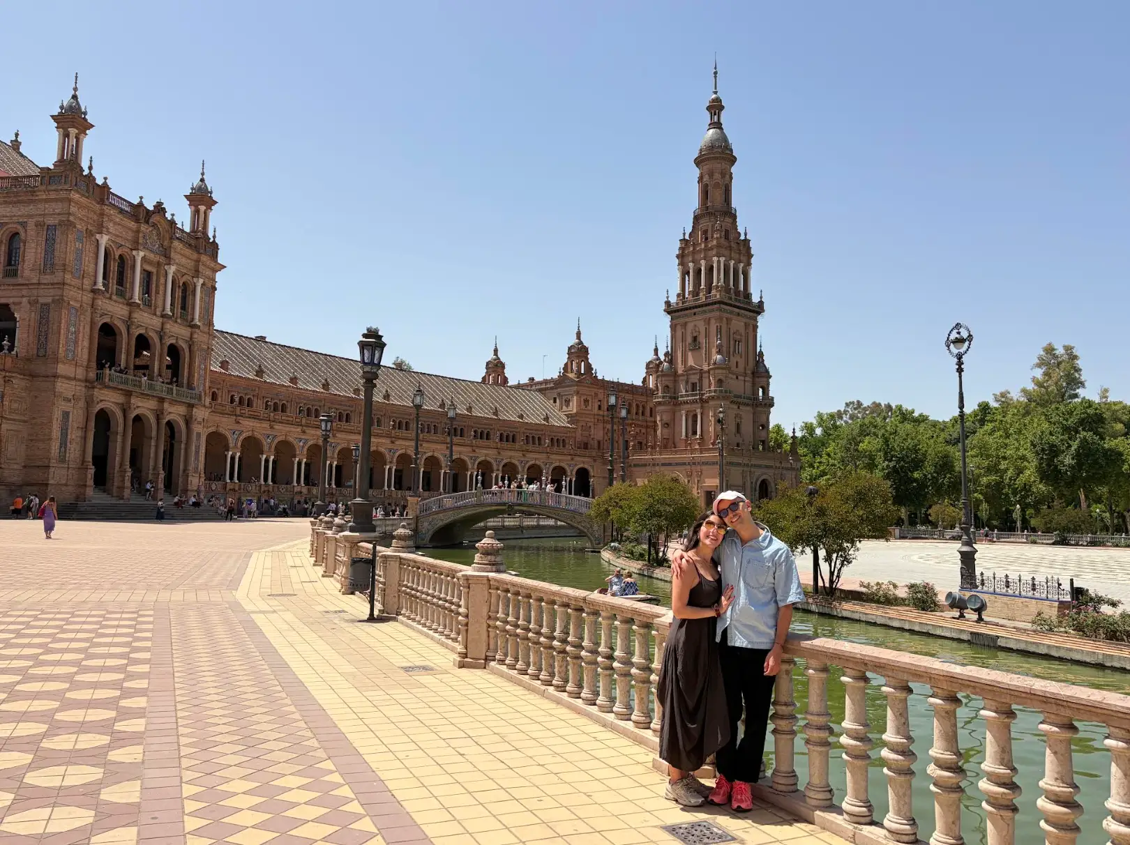 The writer and his partner pose by the canal and ornate towers while on a trip.