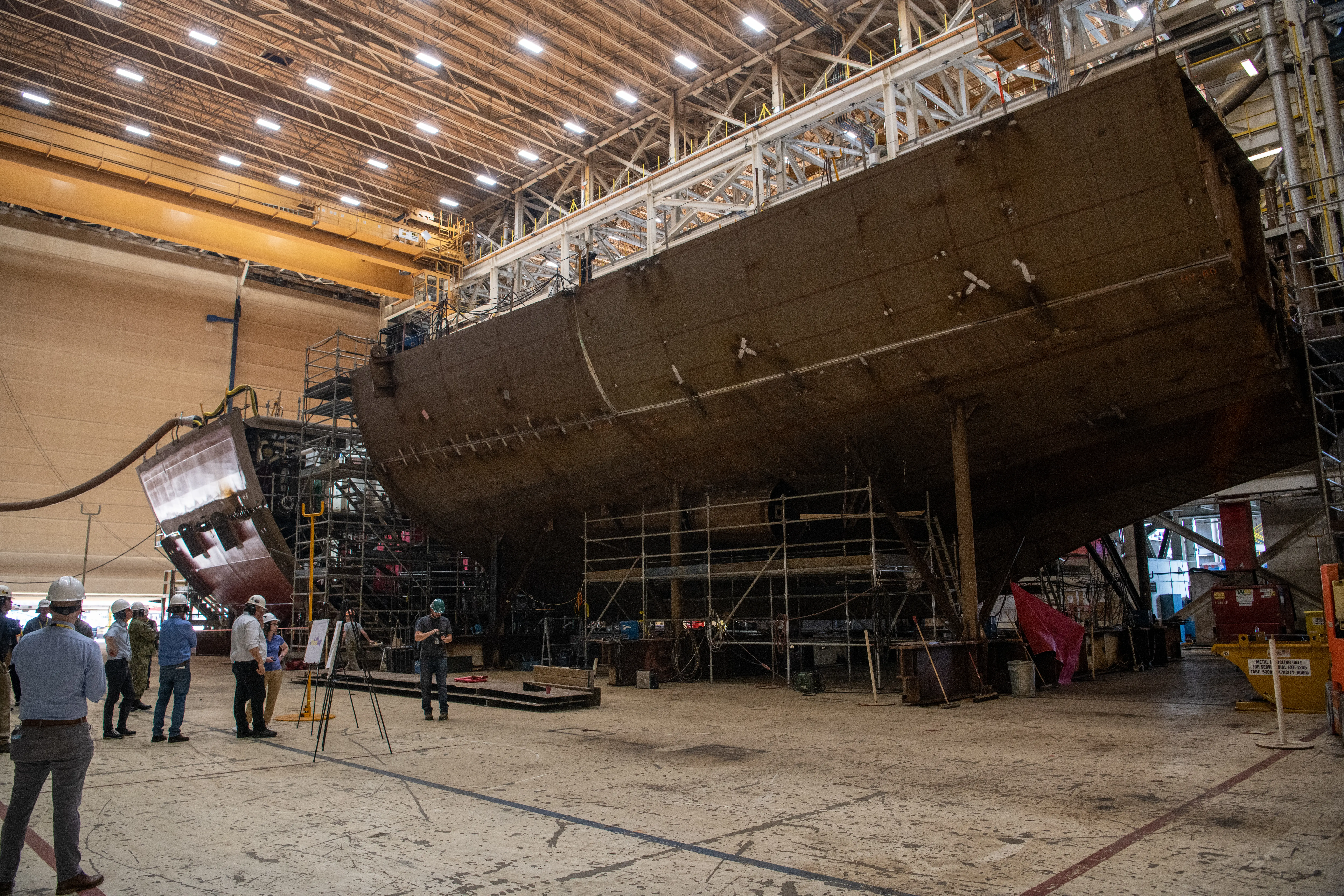 People tour manufacturing facilities at a shipbuilder.