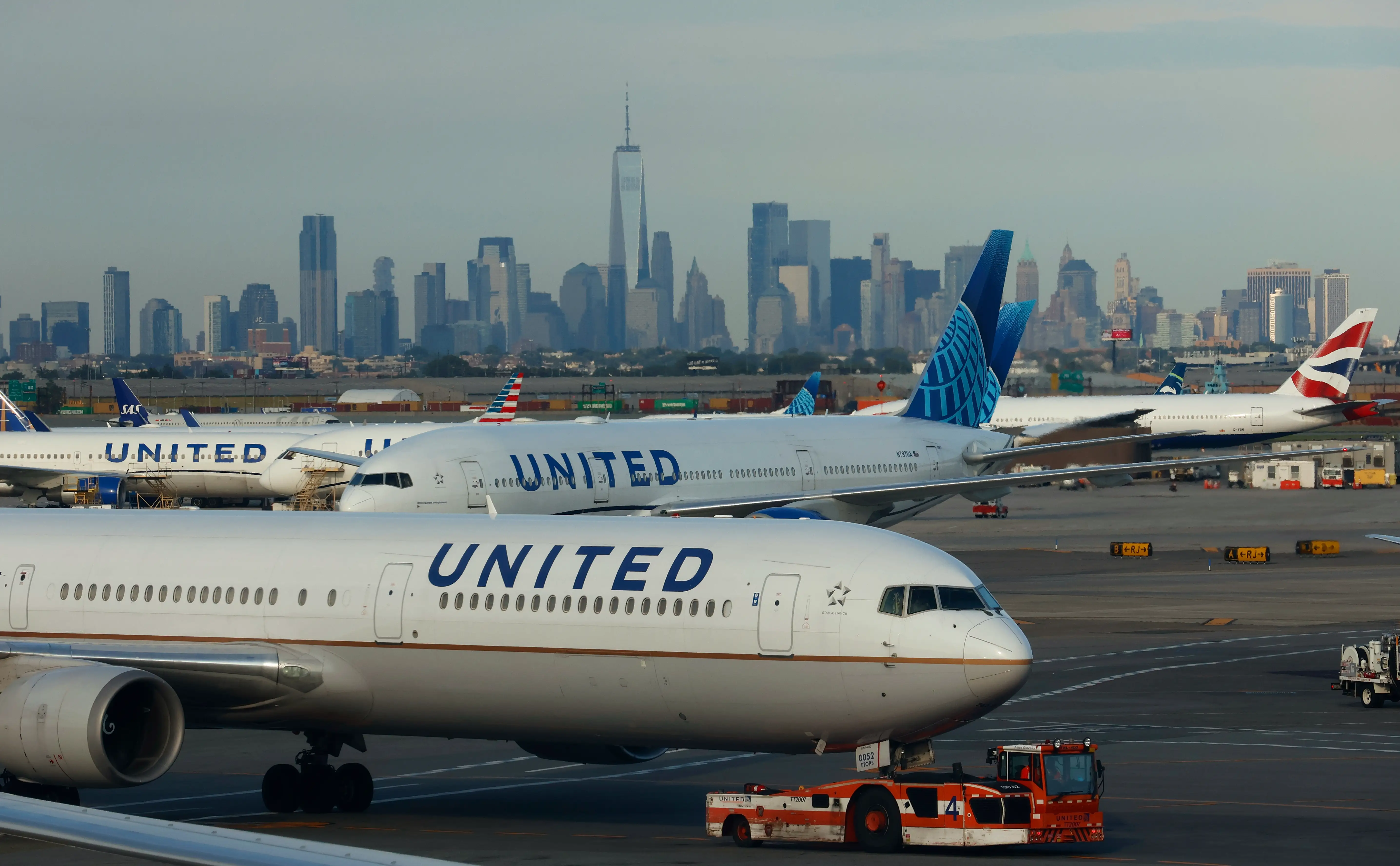 NEWARK, NJ - AUGUST 8: A United Airlines airplane is towed to a gate at Newark Liberty International Airport in front of the skyline of lower Manhattan and One World Trade Center on August 8, 2026, as seen from Newark, New Jersey.