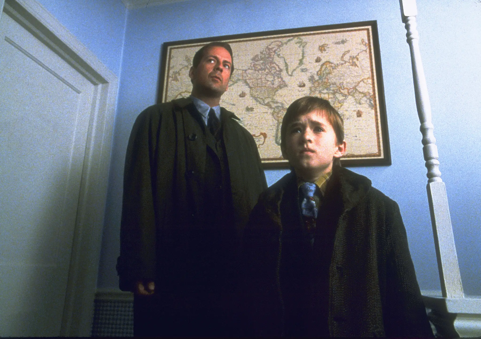 Bruce Willis and Haley Joel Osment standing in a room in The Sixth Sense movie