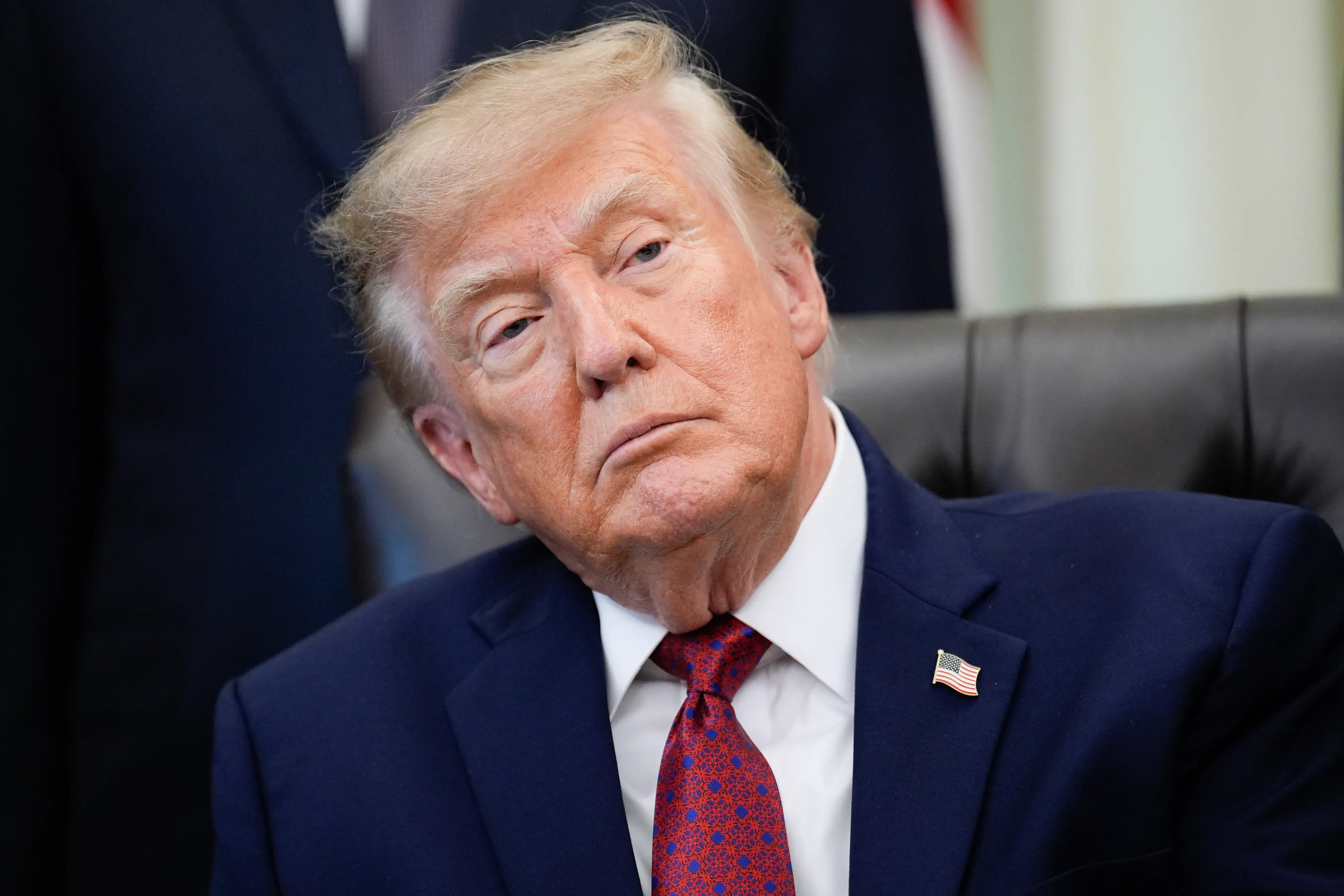 Donald Trump looks out during an announcement in the Oval Office